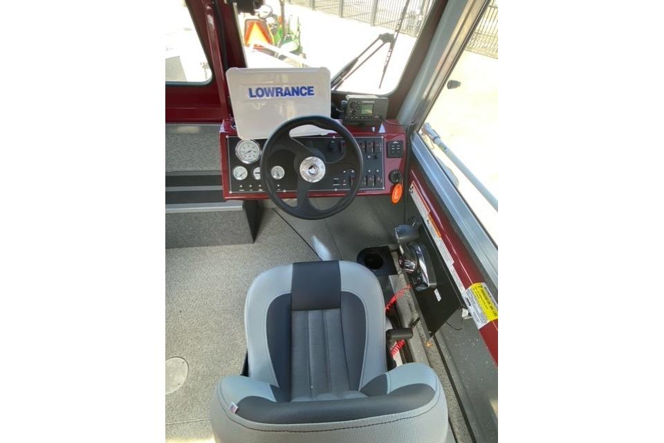 2023 Spartan 200 Astoria boat cockpit with steering wheel and navigation equipment.