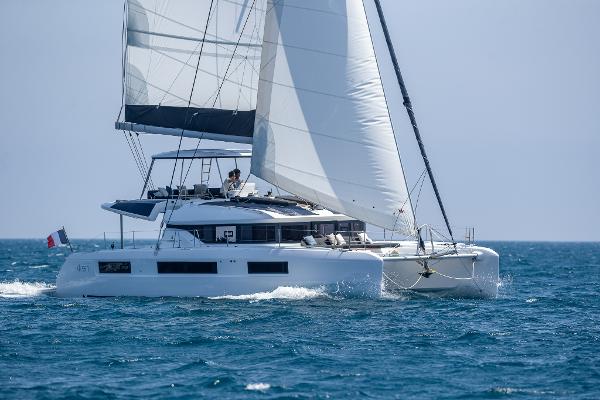 2025 Lagoon 51 ICONIC catamaran sailing on open sea with full sails.