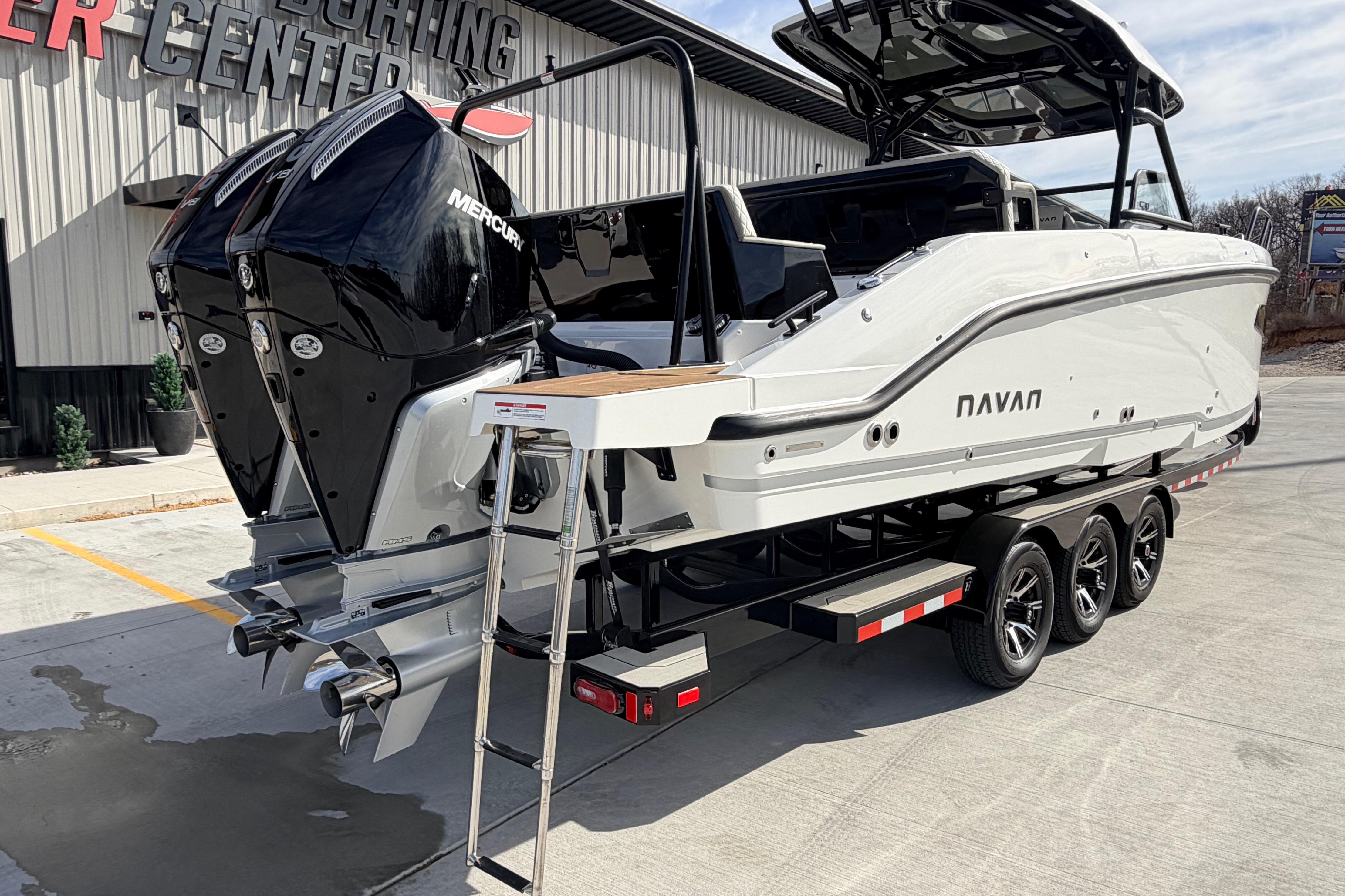 2026 Navan S30 boat with dual Mercury engines on a trailer at a yachting center.