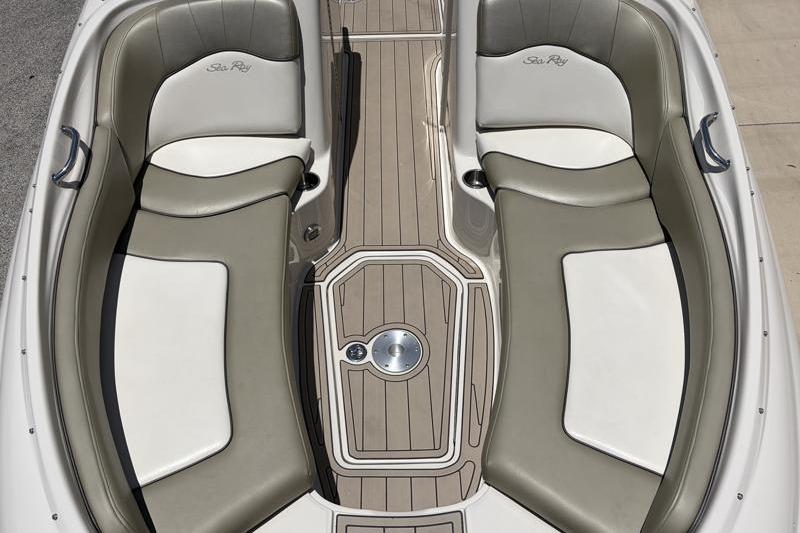 2007 Sea Ray 240 Sundeck interior with beige and white seating, teak-style flooring.