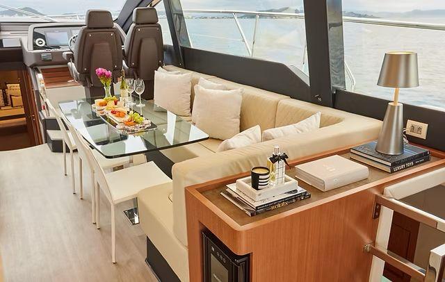 Luxurious interior of 2025 Schaefer 660 yacht with elegant dining area and modern decor.