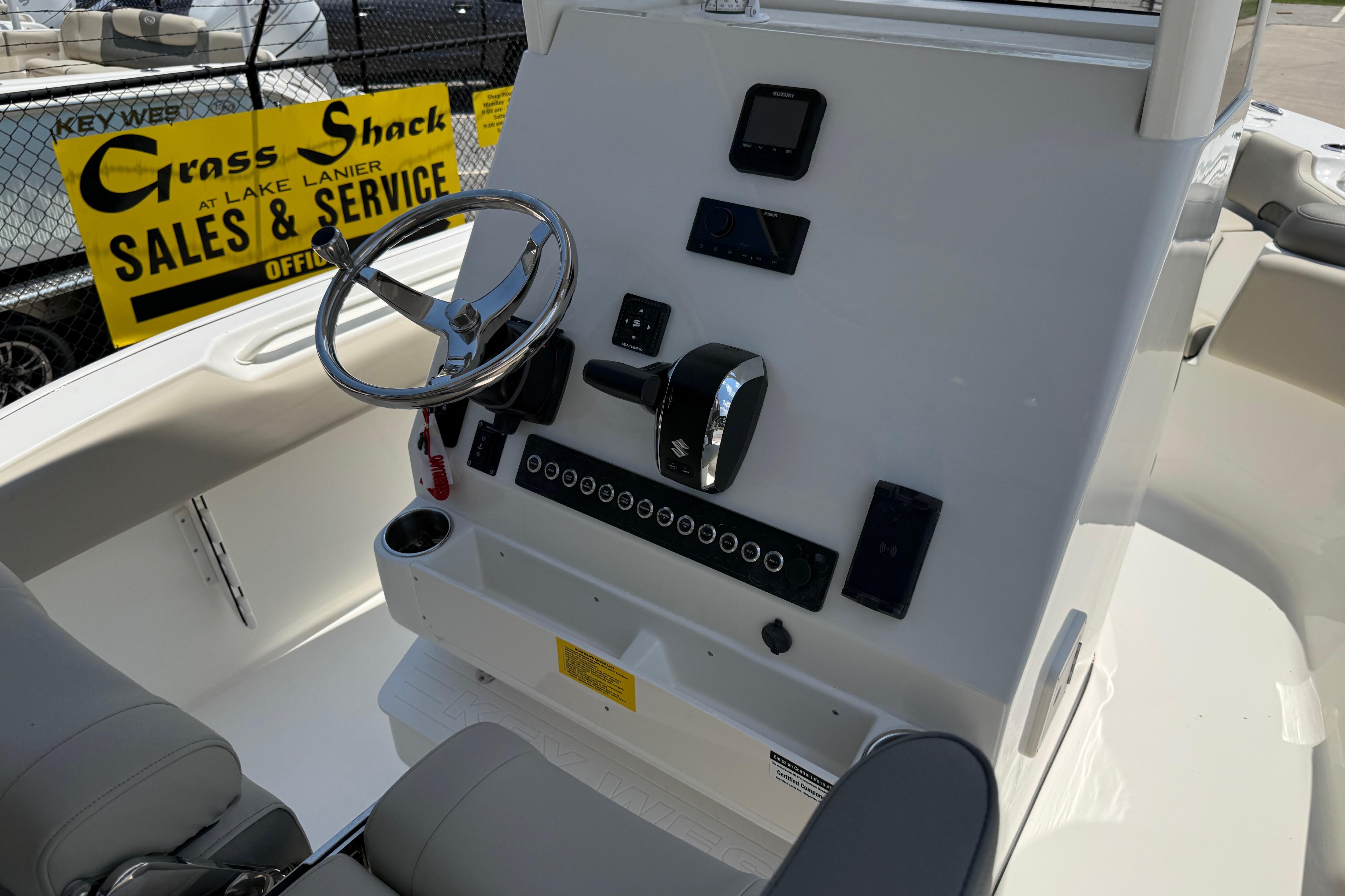 2027 Key West 249 FS boat dashboard with steering wheel and controls at sales service center.
