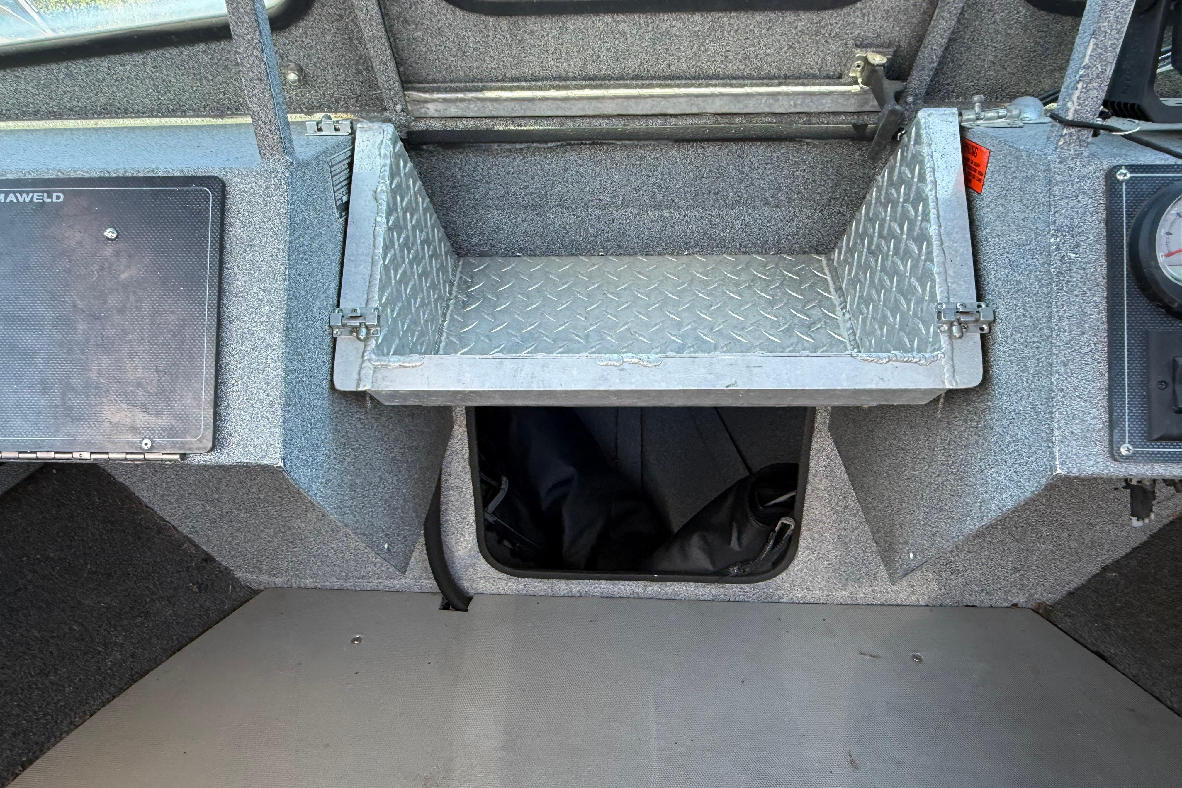 2004 Alumaweld Intruder Outboard 20 interior with storage compartment and dashboard details.