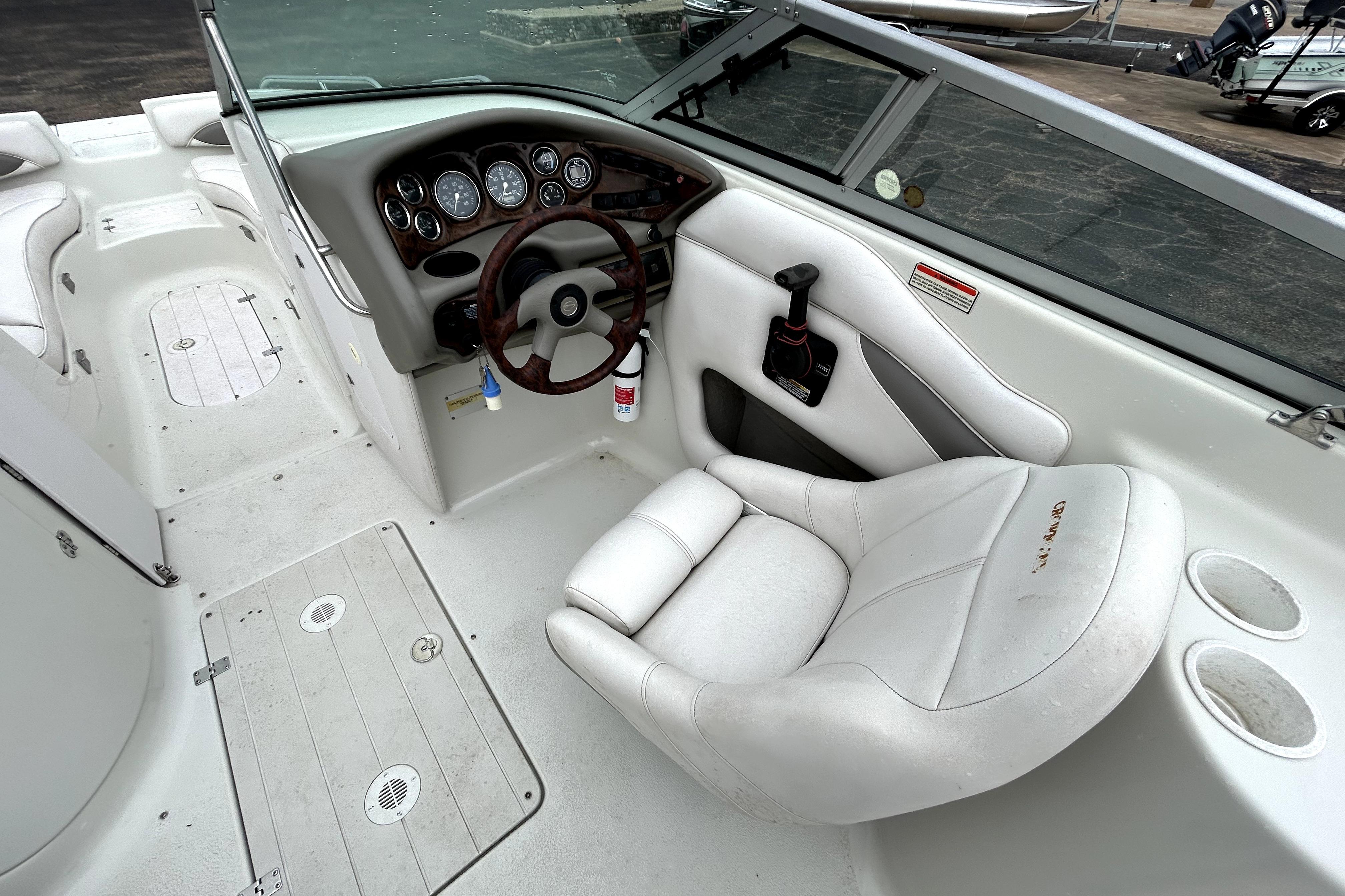 2001 Crownline 239 DB boat interior with steering wheel and white seating.