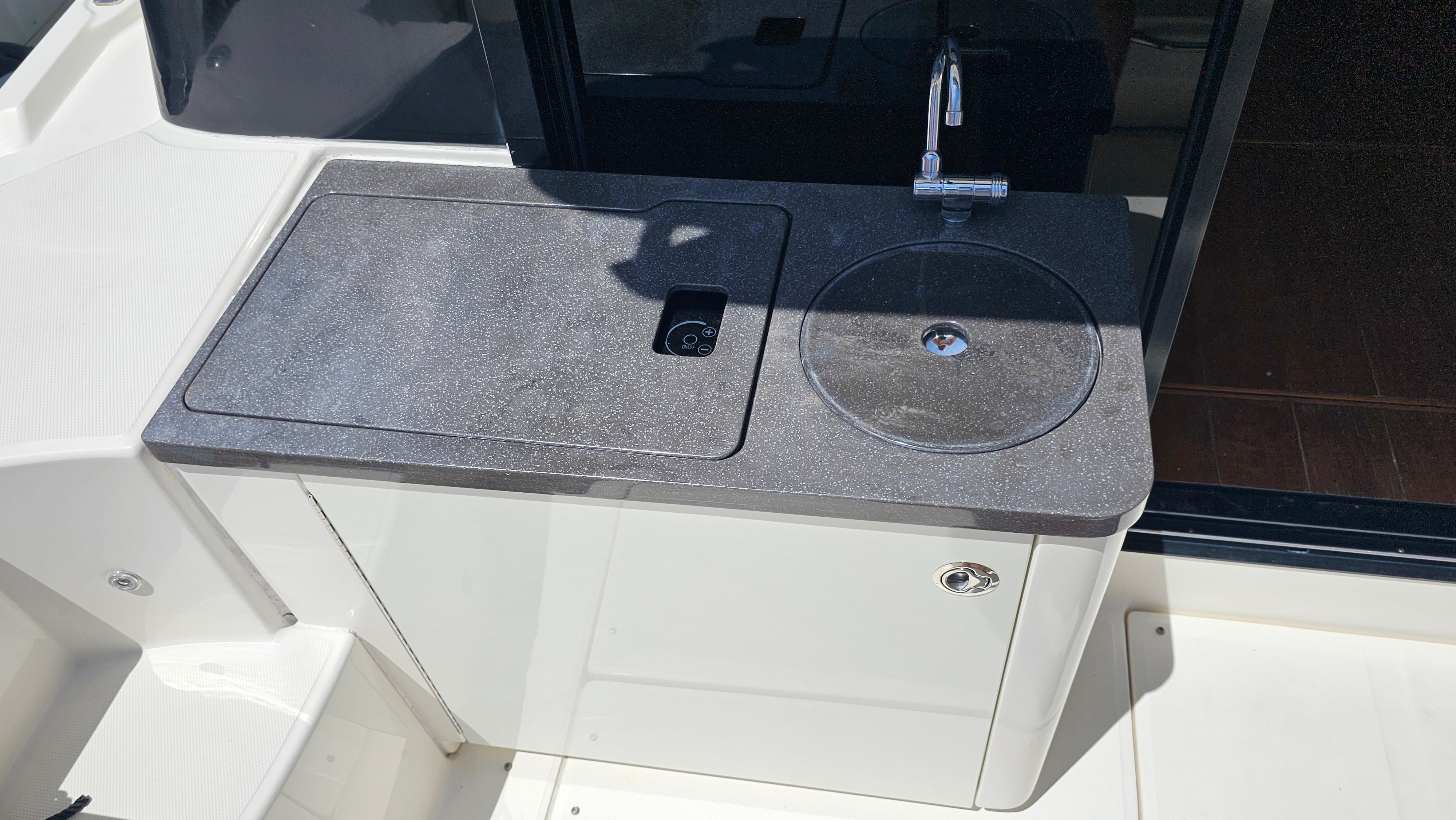 2016 Sea Ray 470 Sundancer outdoor kitchenette with sink and countertop.