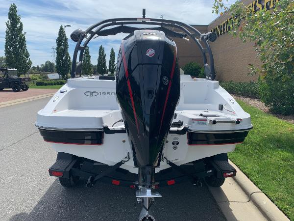 2024 Tahoe 1950 boat with powerful outboard motor, parked on a sunny street.