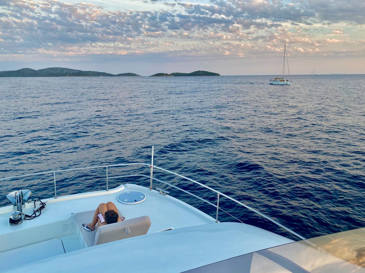 Person relaxing on a 2021 Fountaine Pajot MY6 yacht, enjoying a serene ocean view.
