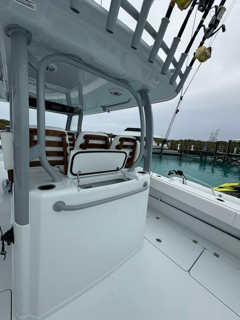 2026 Freeman 38 boat interior with seating and fishing rods, docked by clear blue water.