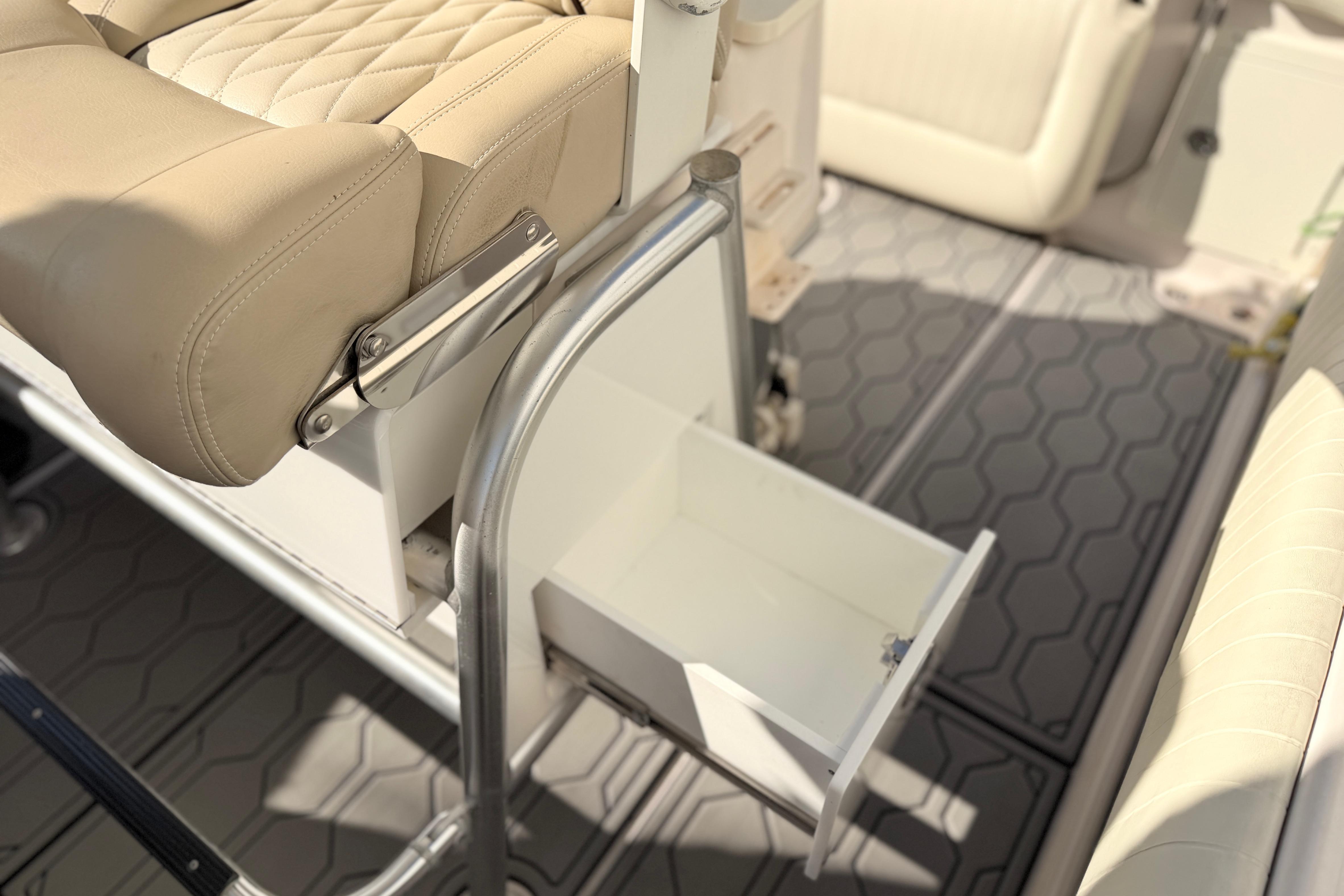 2004 Grady White 273 boat interior with beige seating and open storage drawer.