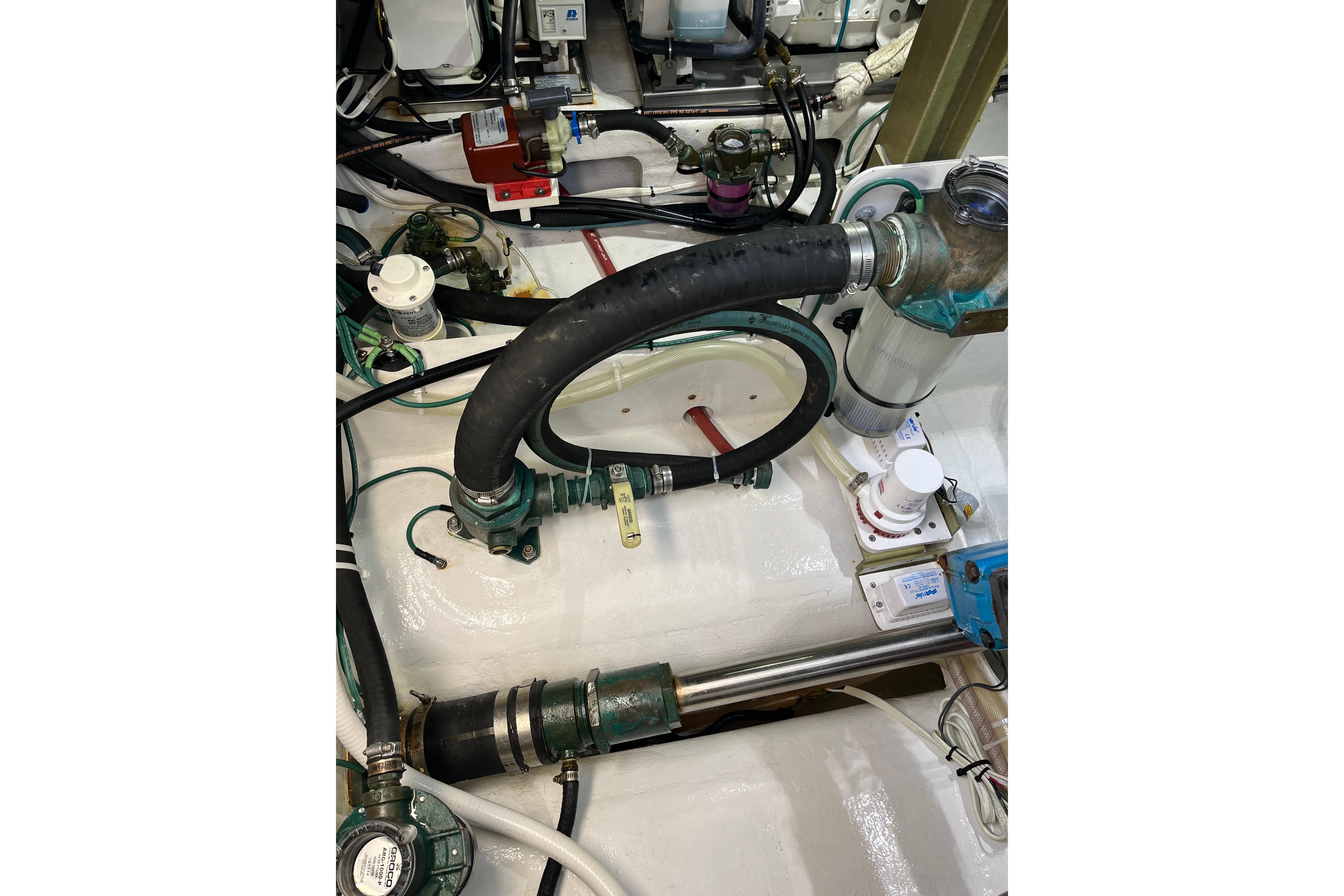 Engine room of 2018 H&H Marine Osmond Beal with hoses and mechanical components.