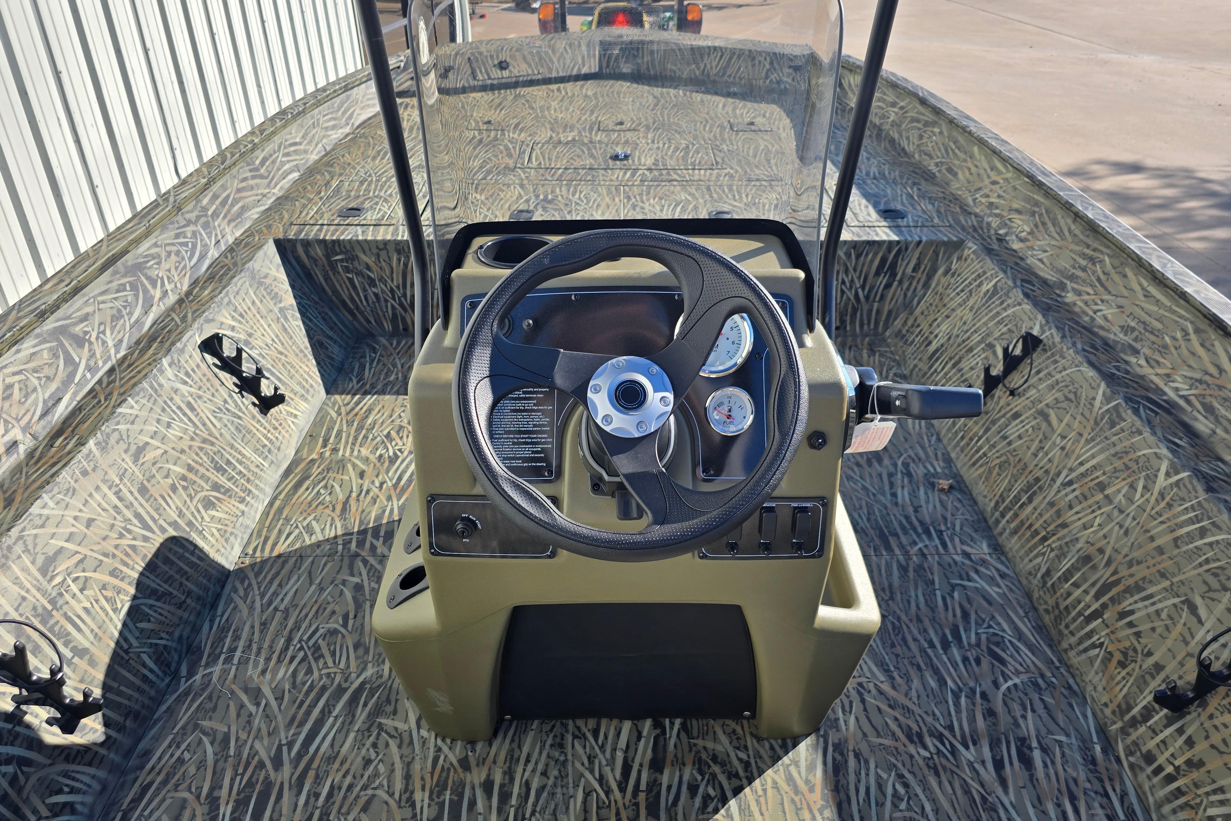 2026 Tracker Grizzly 2072 CC boat interior with camo design and steering console.