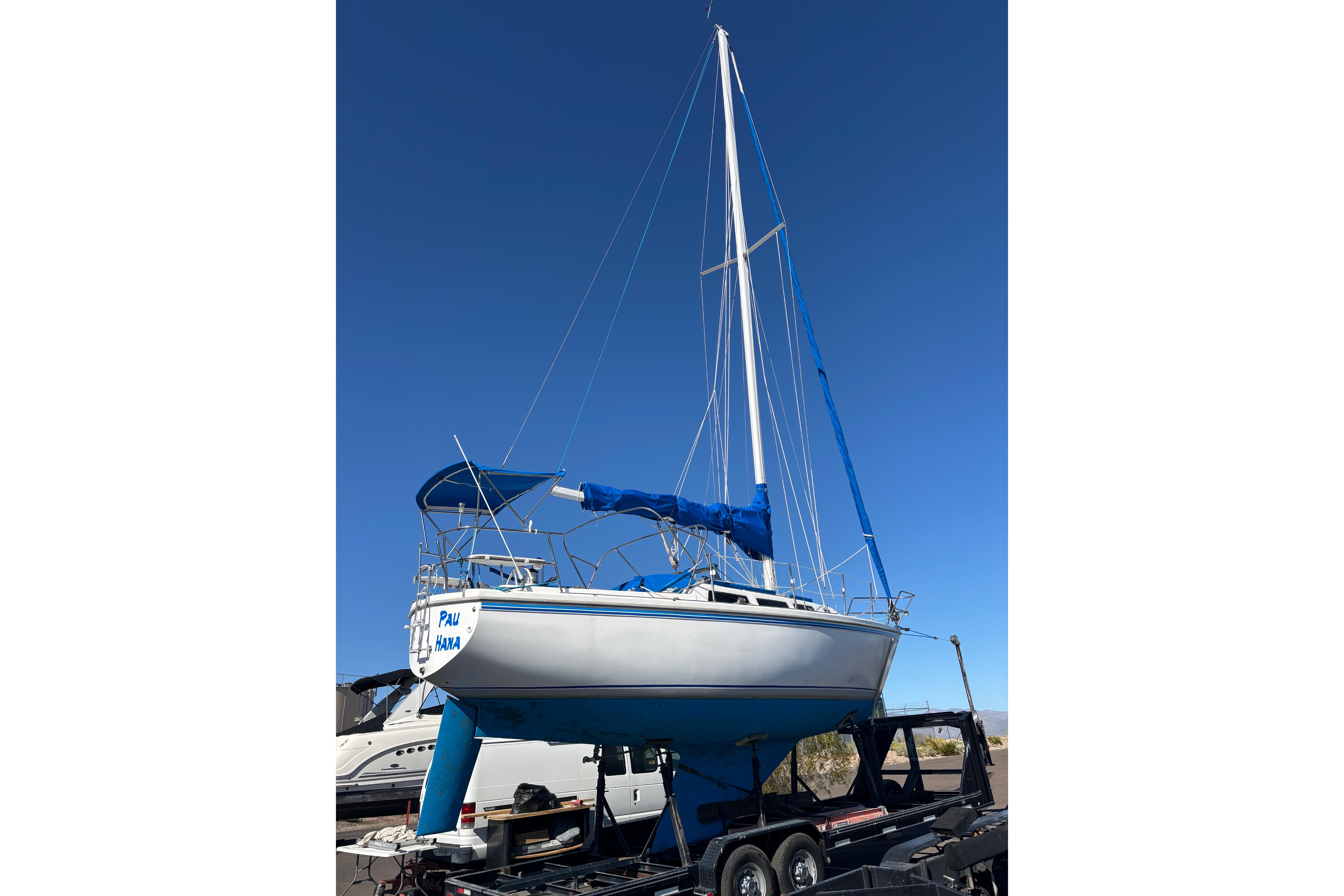 1980 Catalina 30 sailboat on trailer under clear blue sky.