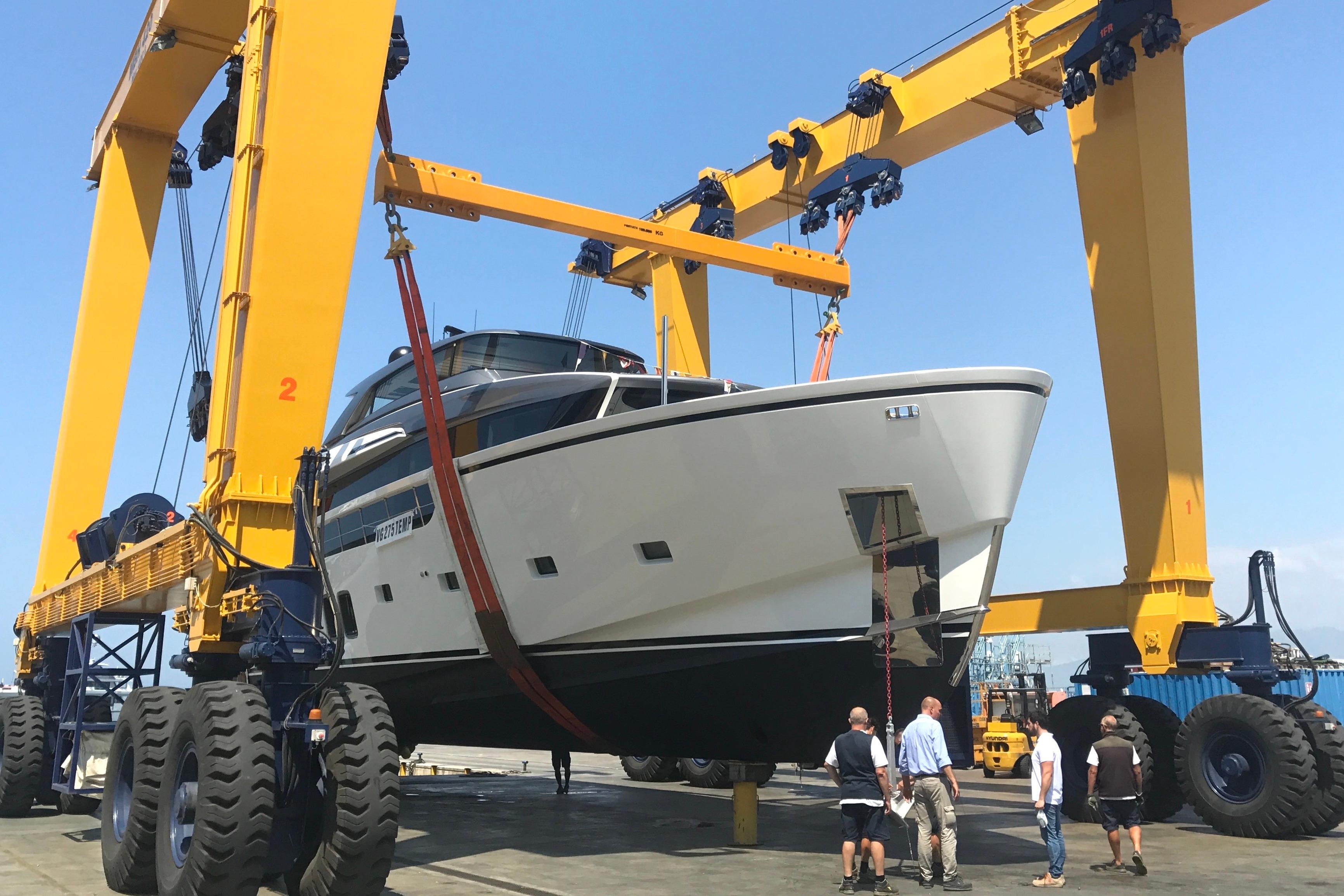 Sanlorenzo SX88 yacht from 2018 being lifted by a large yellow crane.