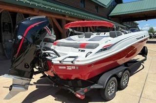 2026 Tahoe T21 boat with red and white design on a trailer, parked outdoors.