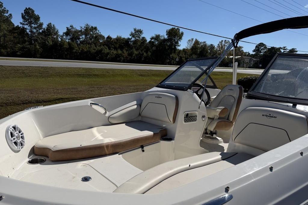 2024 Stingray 191 DC boat interior with seating and steering wheel, parked outdoors.