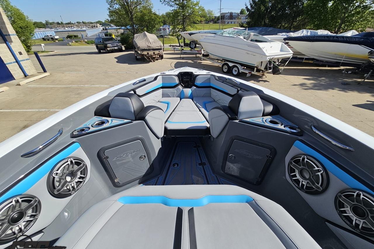 2025 Sunsation 32 CCX boat interior with modern seating and audio system in a marina setting.