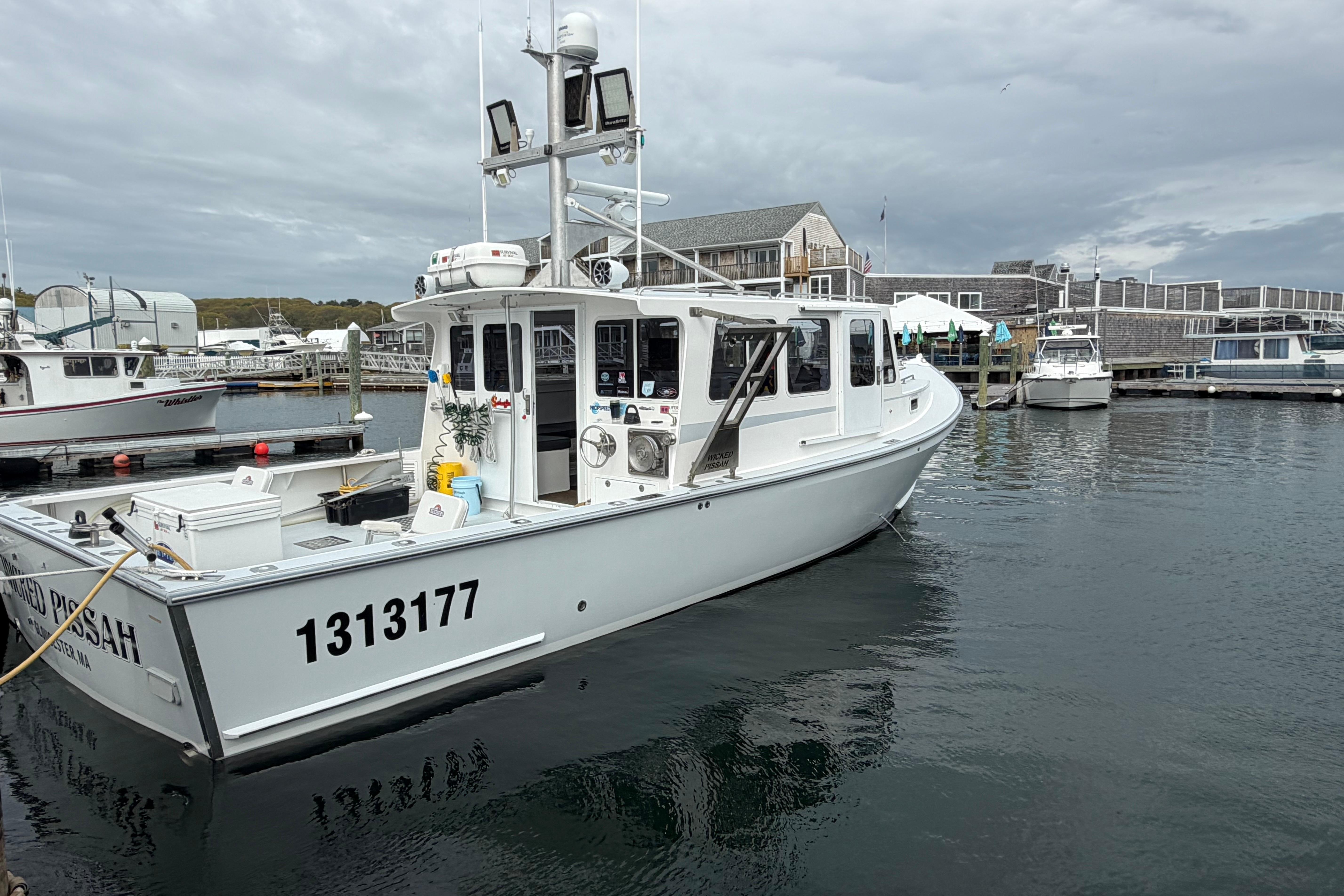 2018 H&H Marine Osmond Beal boat docked at a marina under cloudy skies.