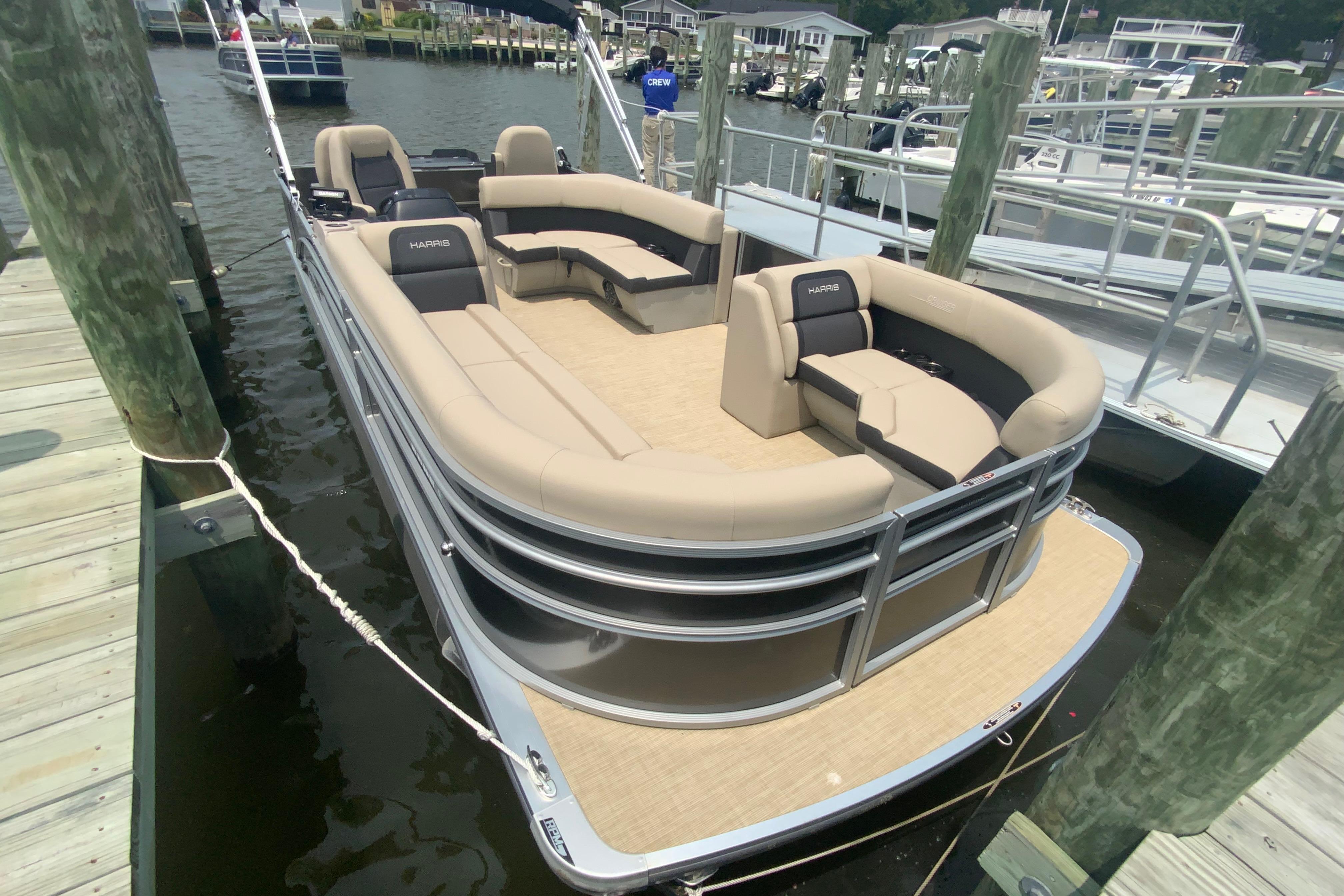 2025 Harris Cruiser 230 pontoon boat docked, featuring spacious seating and modern design.
