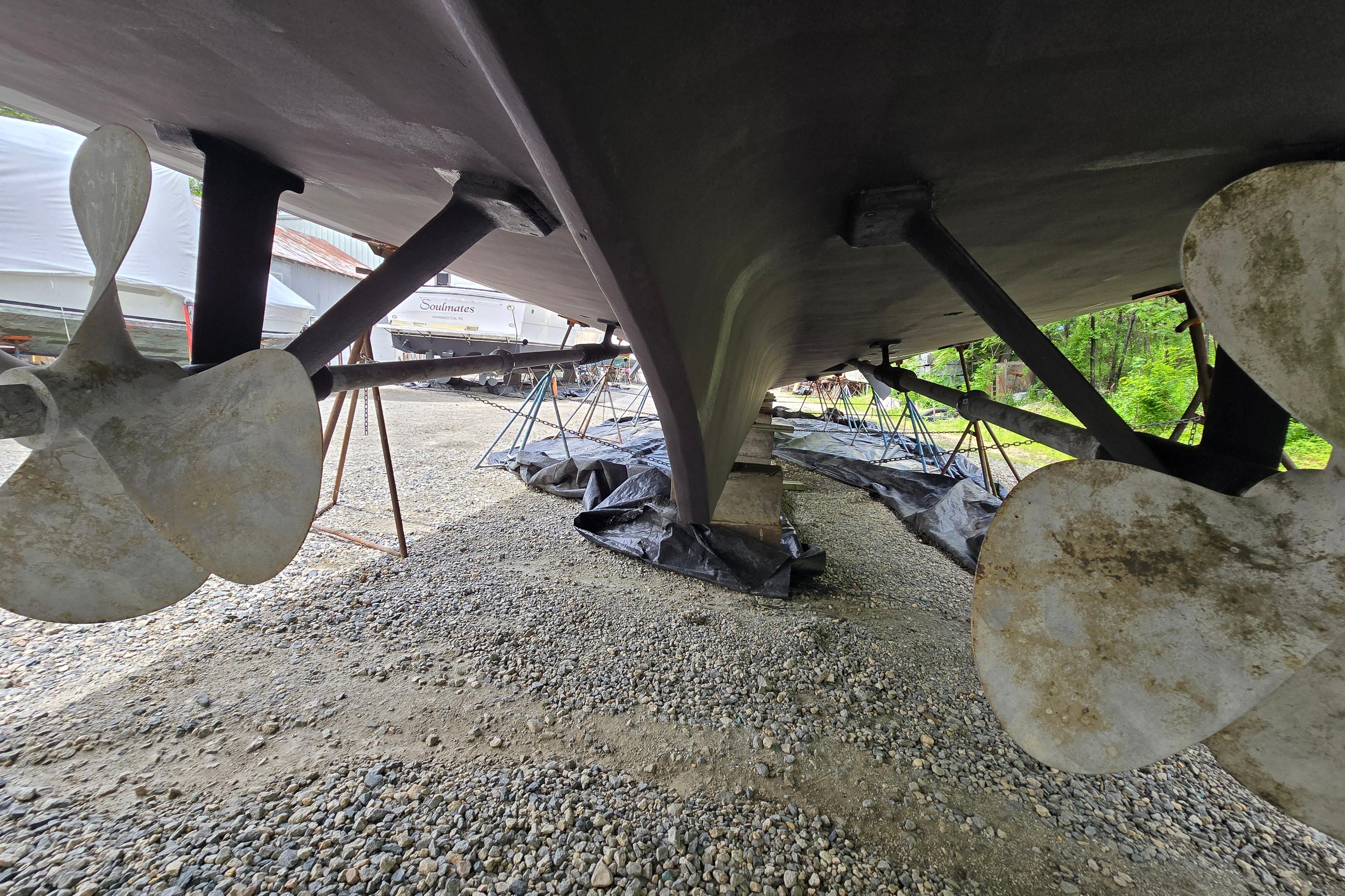 Underside view of 1980 Hatteras 70 Motor Yacht with visible propellers and supports.