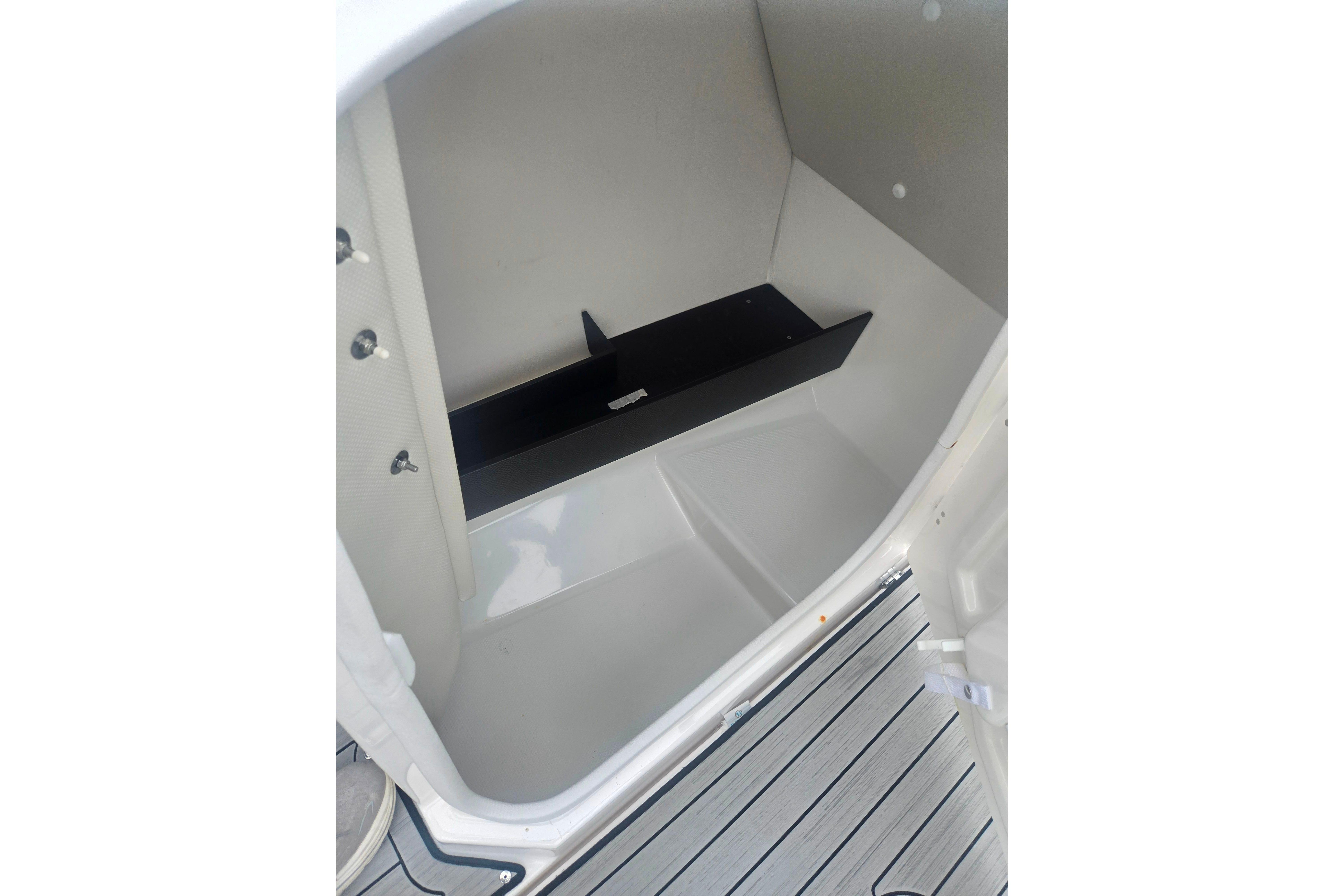 2023 Yamaha Boats 252S interior storage compartment with sleek design and black shelf.