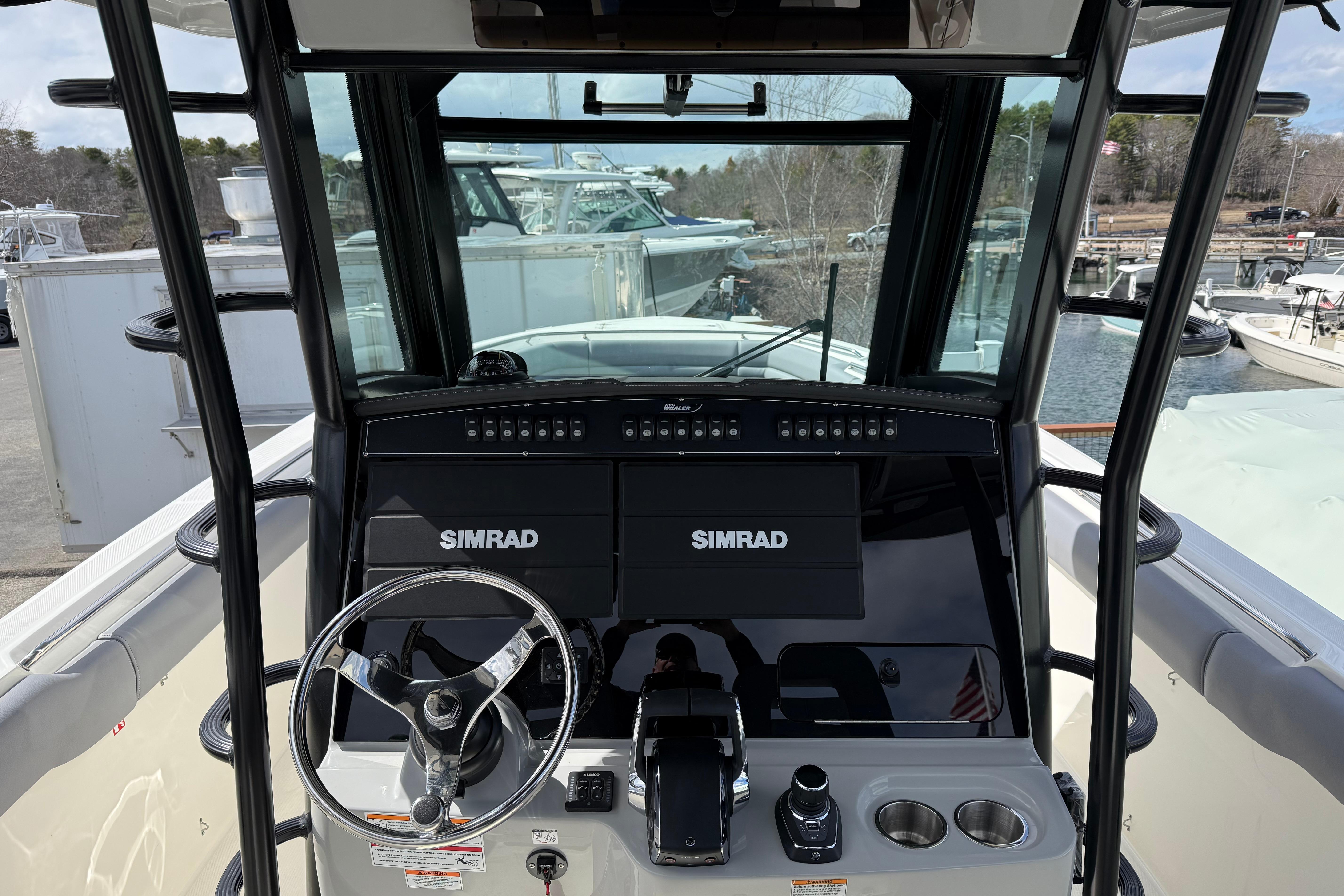 2026 Boston Whaler 330 Outrage helm with Simrad electronics and steering wheel.