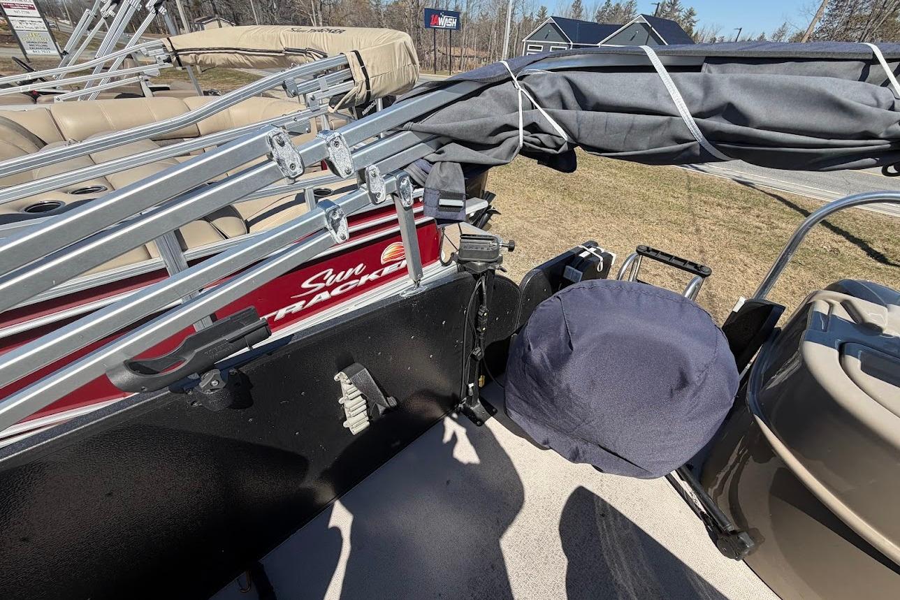 Pontoon boat with folded canopy, Premier 221 Explorer, 2013 model, parked on grass.