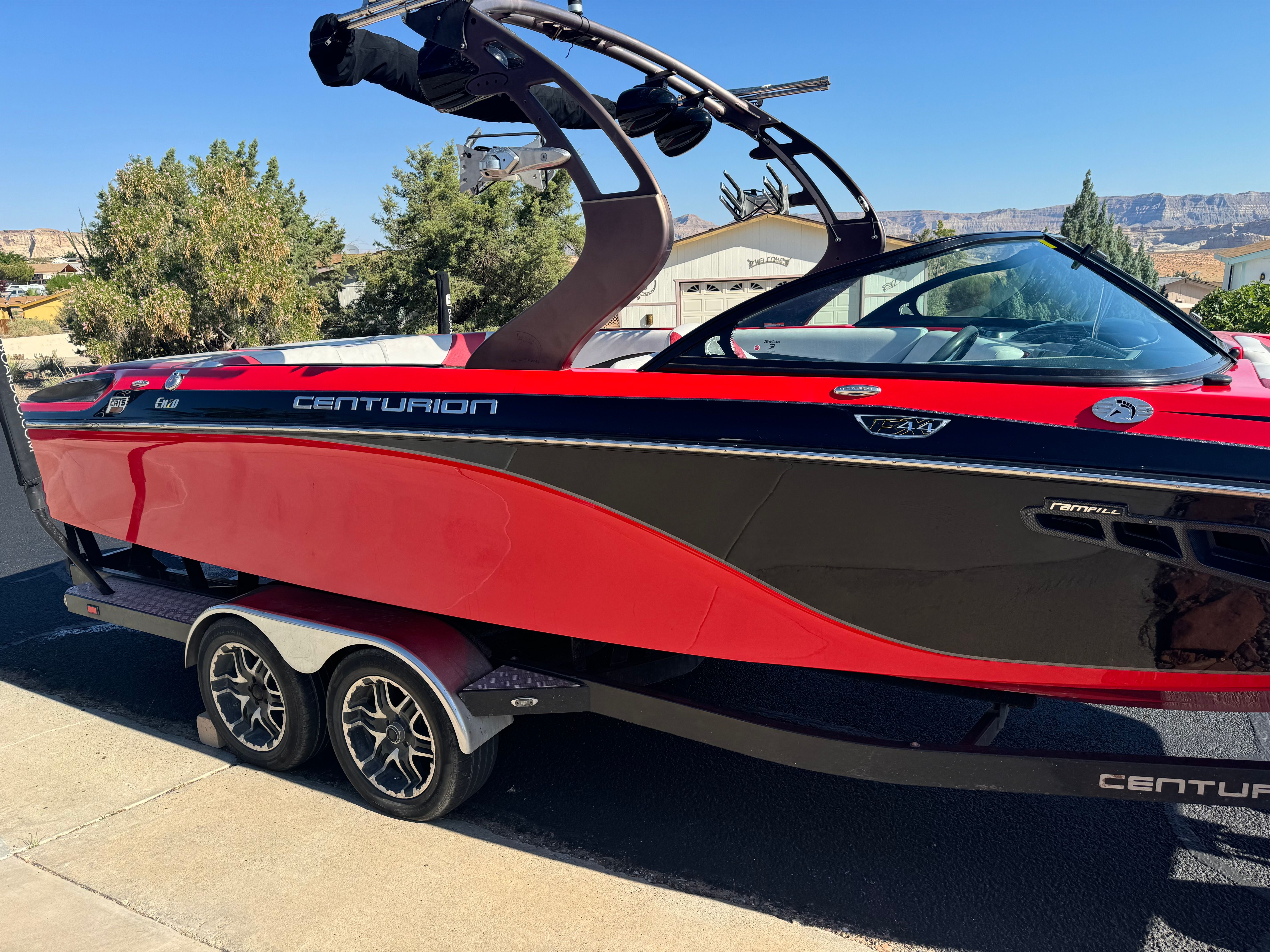 2014 Centurion Enzo FX44 boat in red and black on trailer.