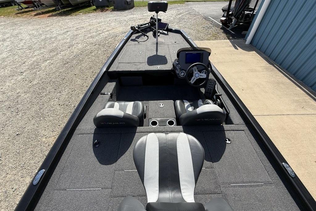 2023 Vexus AVX189 boat interior with steering console and seating, parked on gravel.