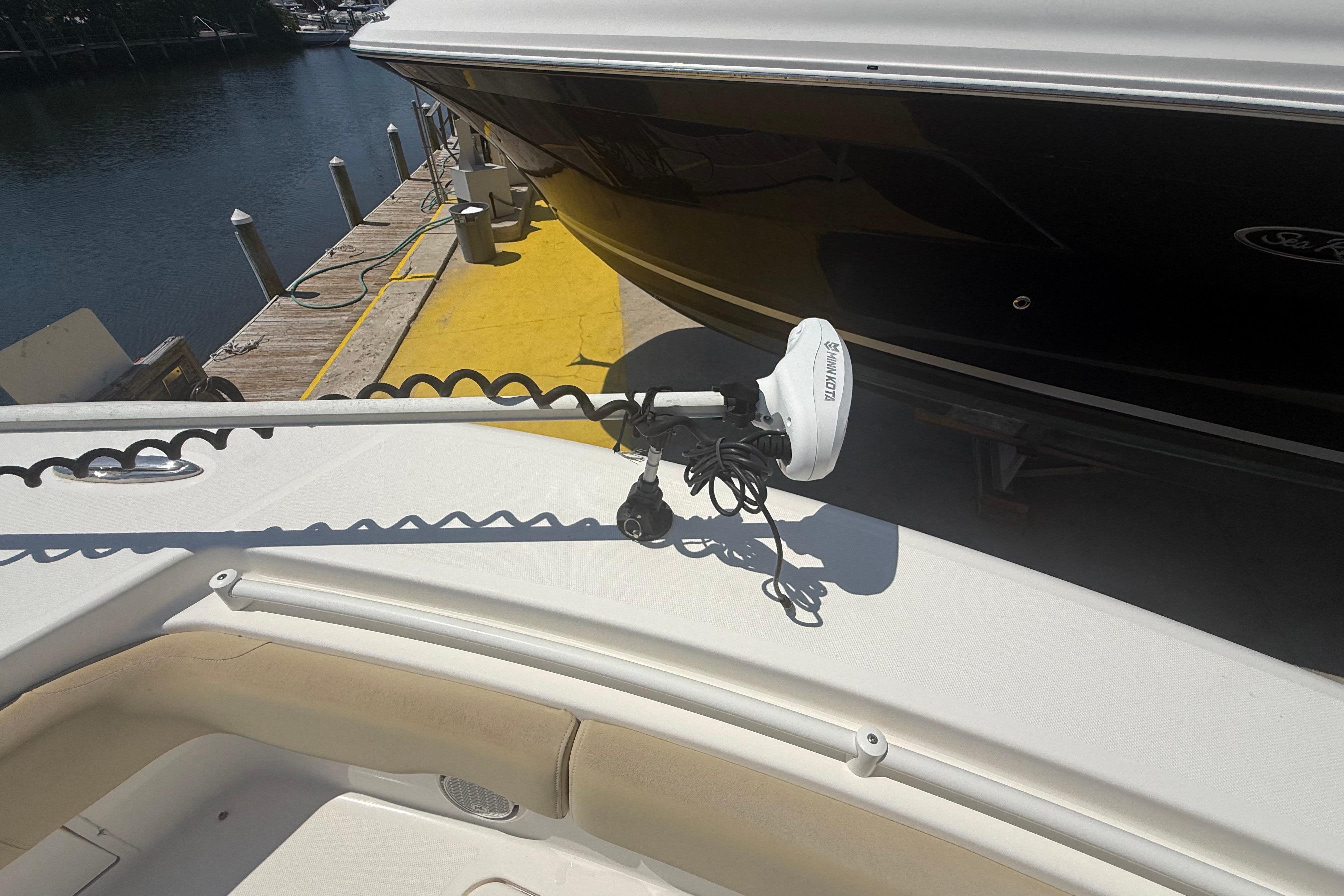 2019 Key West Billistic 281 Center Console with Minn Kota trolling motor docked by water.