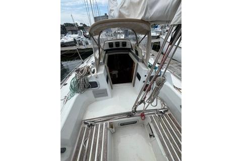1986 Beneteau First 305 sailboat cockpit with ropes and open cabin entrance.