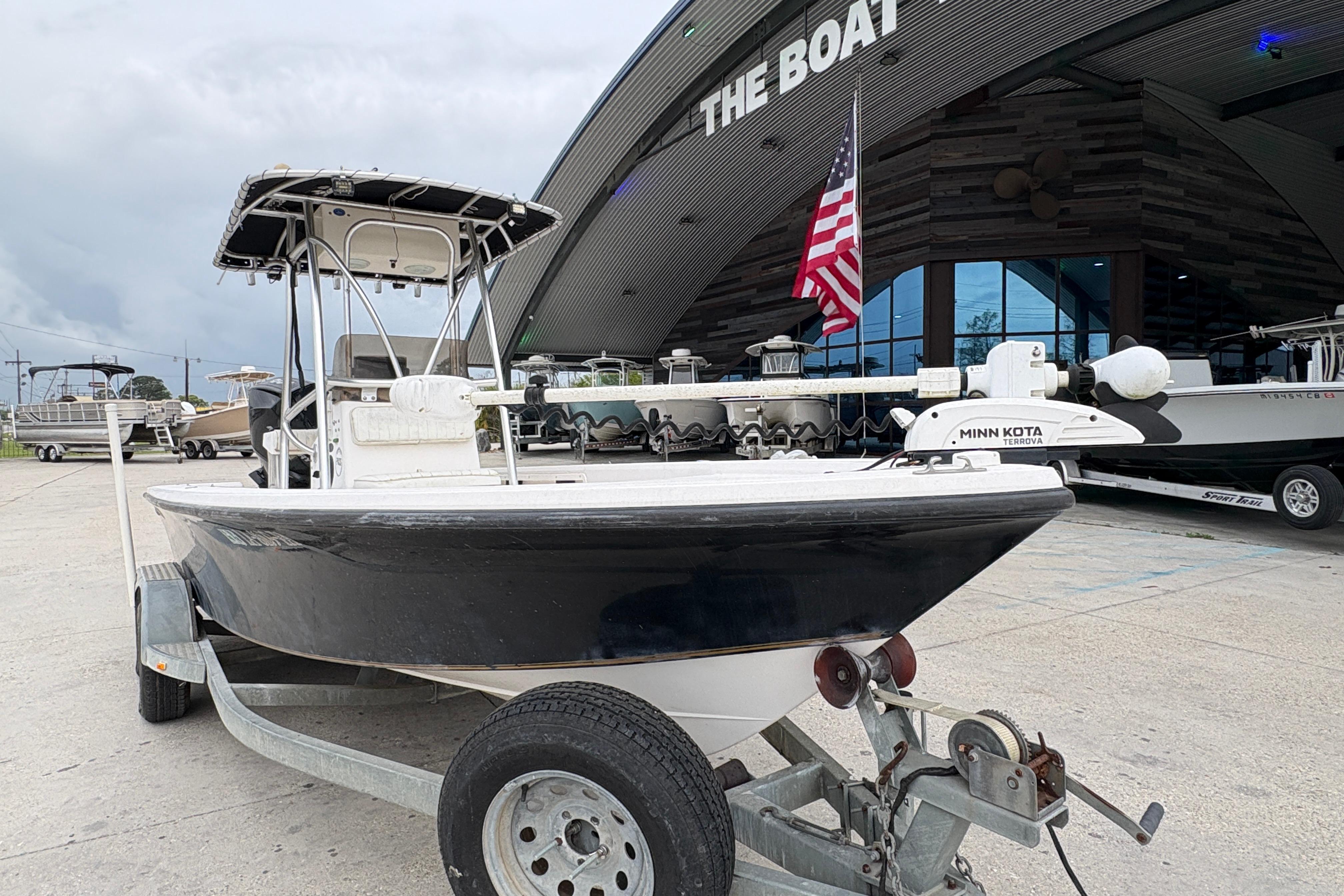 Kenner 21 VISION 2000 boat on trailer outside dealership with American flag.
