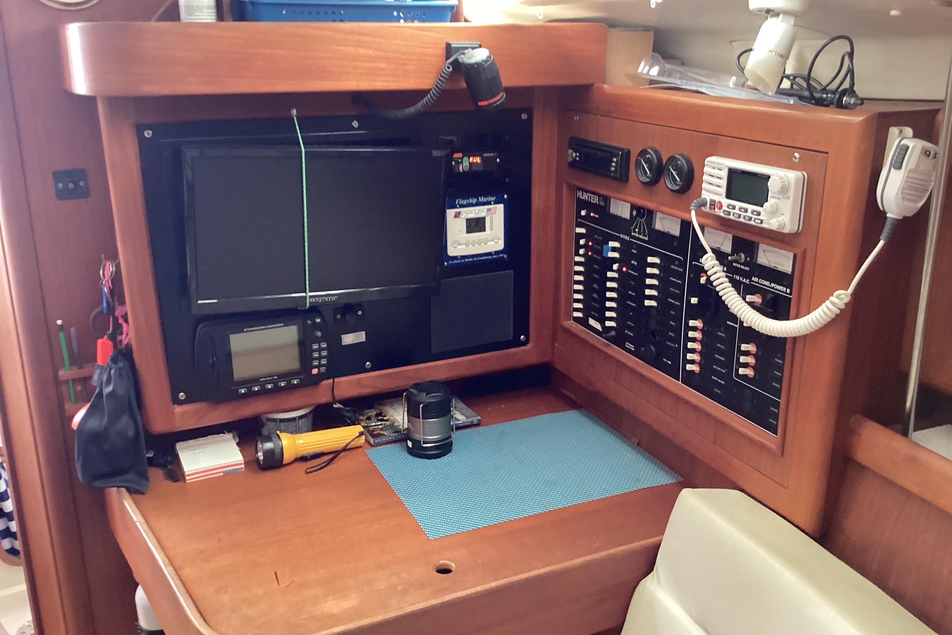 Navigation station of a 2001 Hunter 380 sailboat with control panels and equipment.