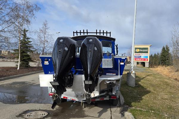2024 Spartan 26 Maximus Pro XL boat with dual outboard motors in a parking lot.