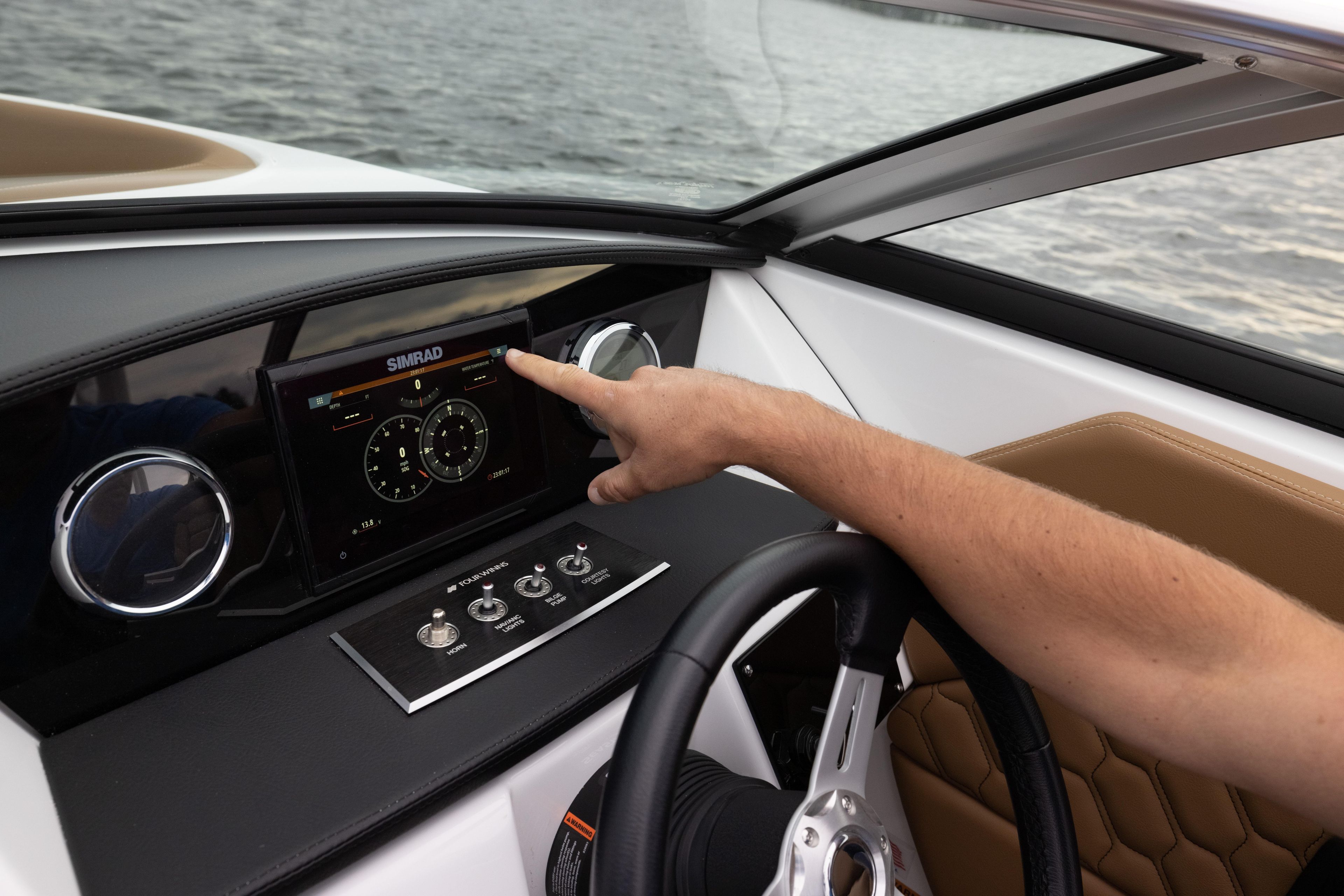 2026 Four Winns H1 OB dashboard with Simrad display and steering wheel on water.