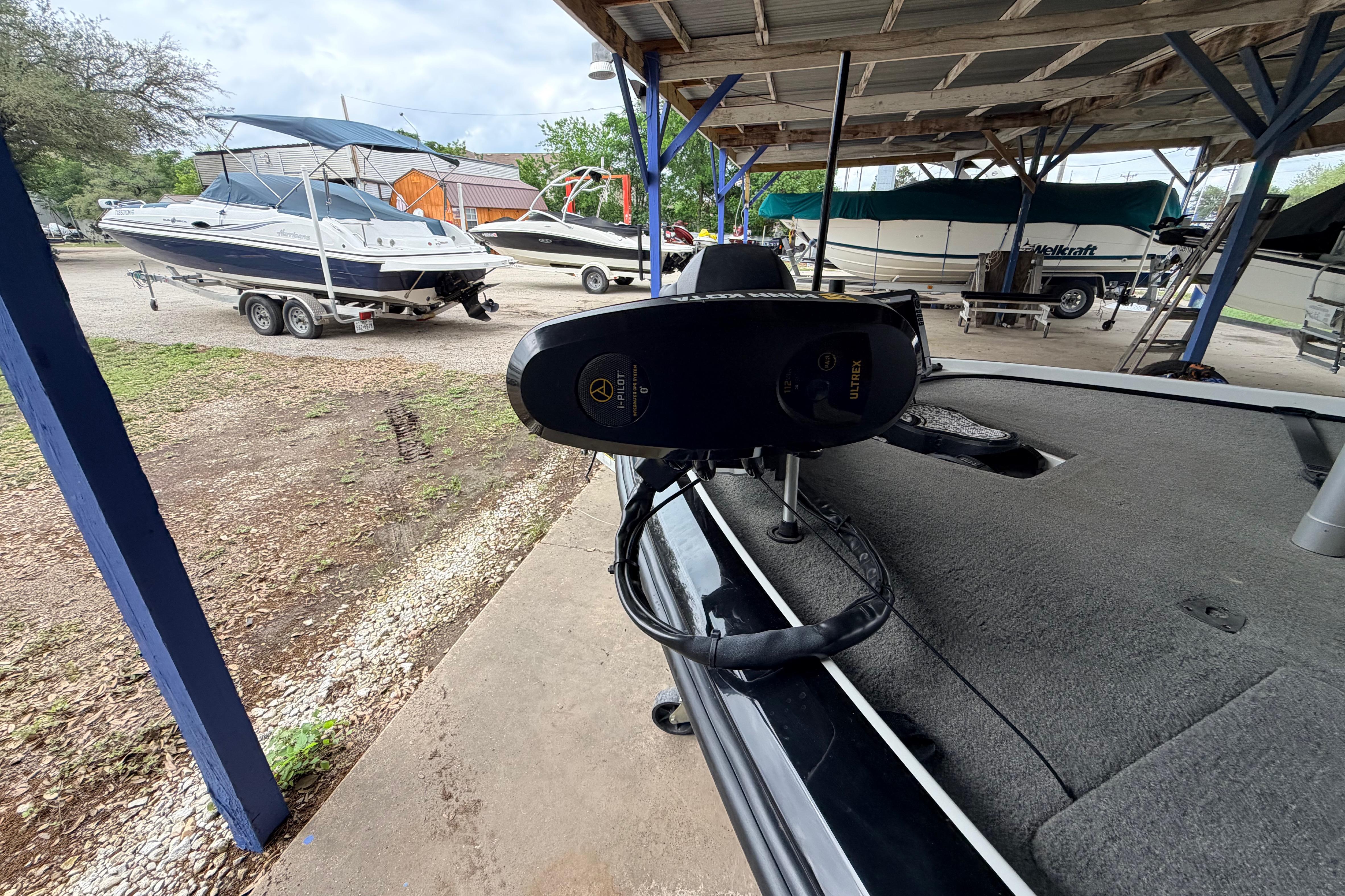 2016 Nitro Z20 boat with trolling motor, parked under a shelter with other boats nearby.