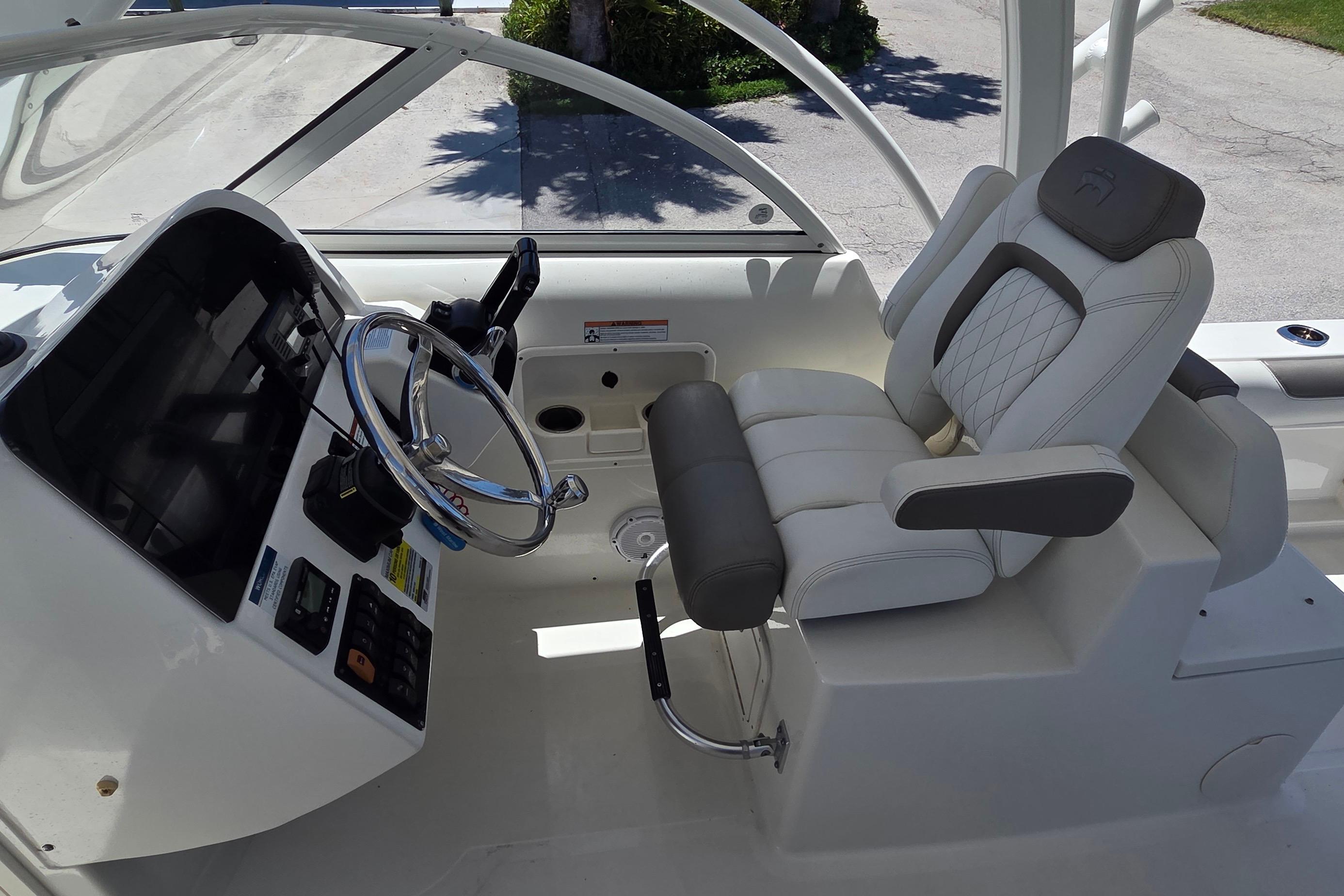 Interior of 2022 World Cat 255 DC boat with steering wheel and captain's chair.