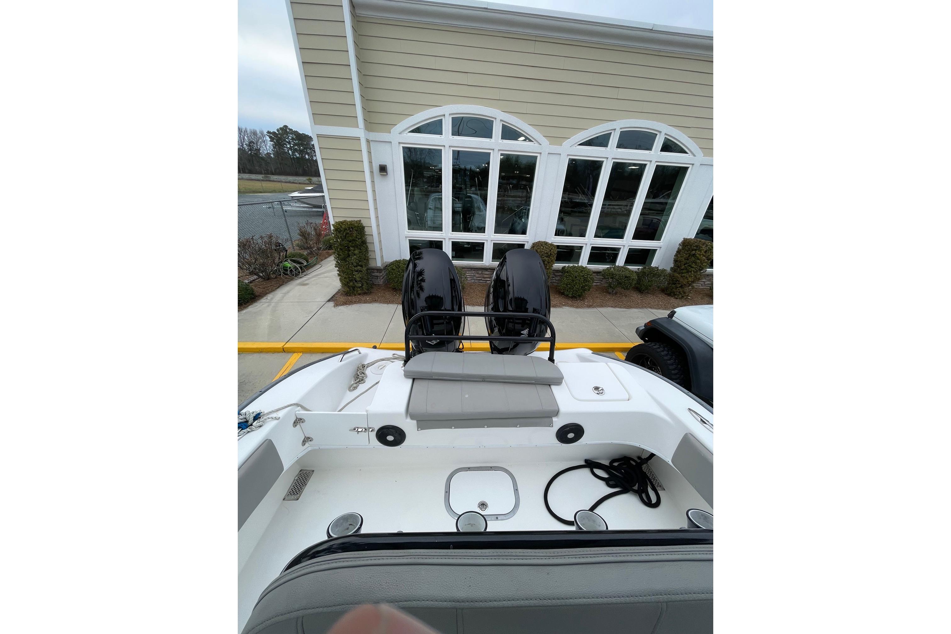 2023 Cape Horn 24 XS boat interior with seating and storage, parked near a building.