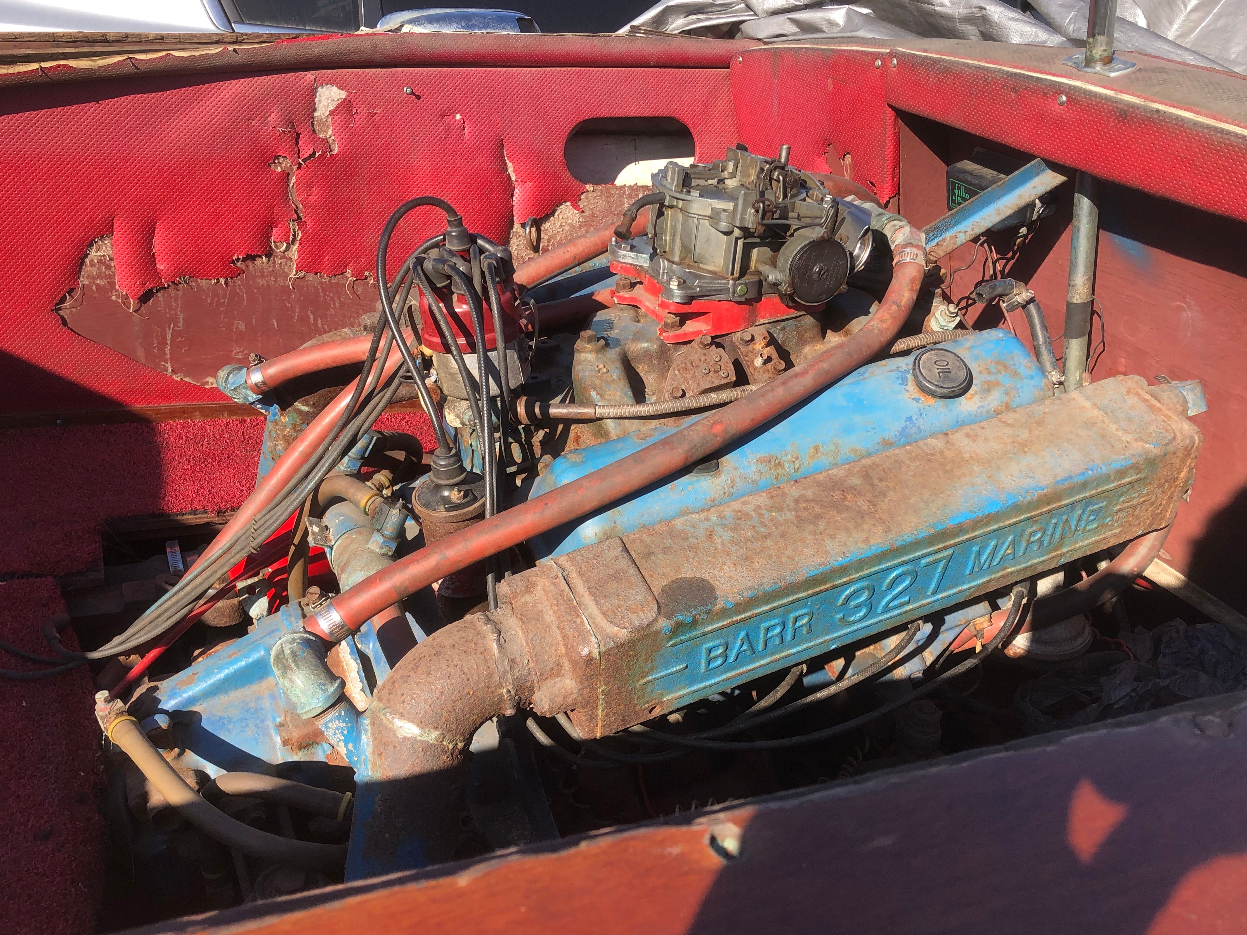 A 1960 Century Resorter with a Barr 327 Marine engine in a worn engine compartment.