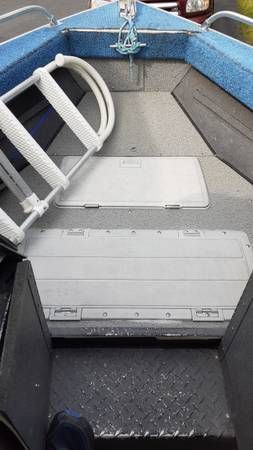The boat has an open bow area with blue padding and a rope.