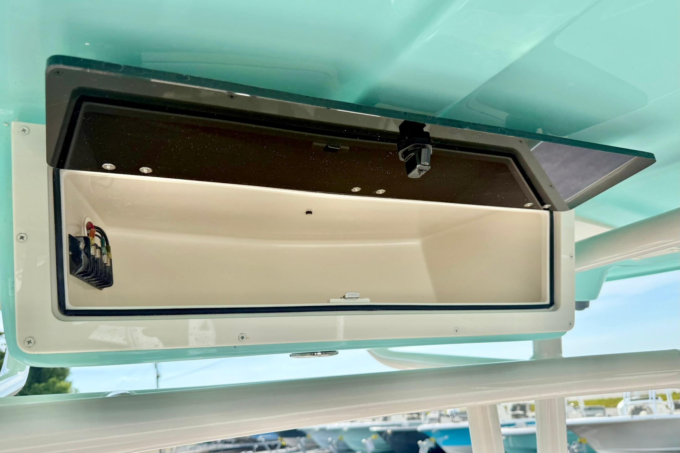 2026 Carolina Skiff 24 Ultra Elite storage compartment, open and empty, with visible wiring.