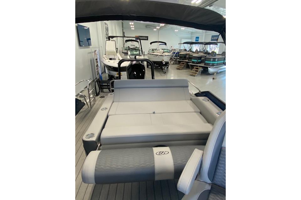 2026 Bentley Pontoons Elite 223 Swingback interior, showcasing luxurious seating in a showroom.