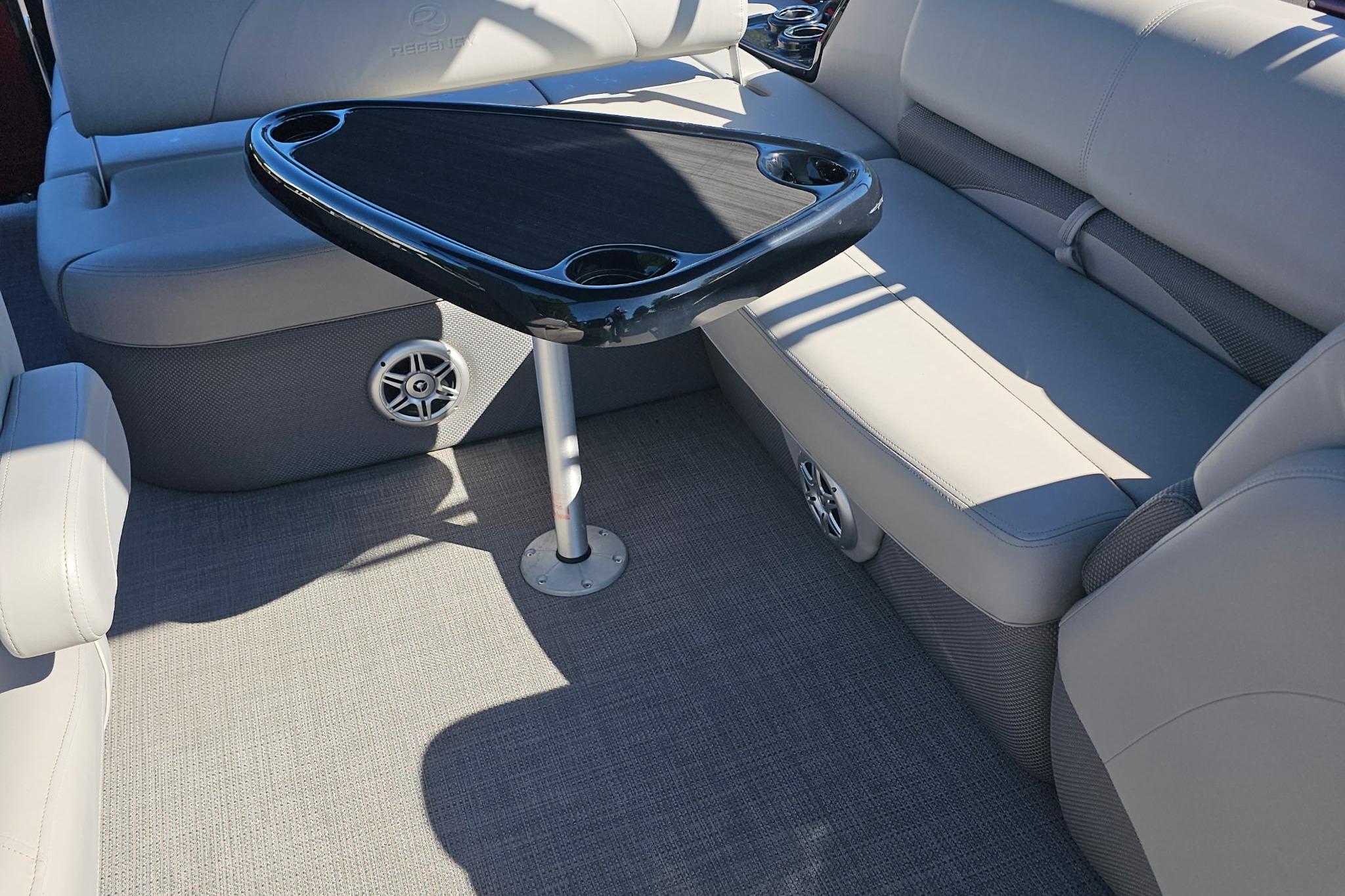 Luxurious seating area on 2023 Regency 250 DL3 boat with sleek table design.