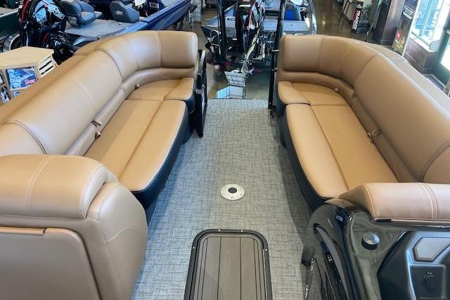 Luxurious interior of 2026 Regency 230 DL pontoon boat with tan seating and gray flooring.