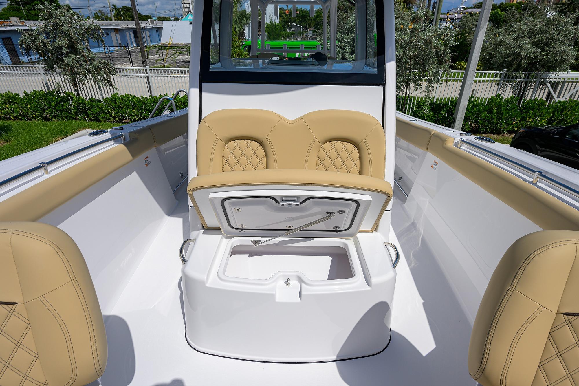 2026 Sportsman Open 302 Center Console boat interior with tan seating and storage compartment.