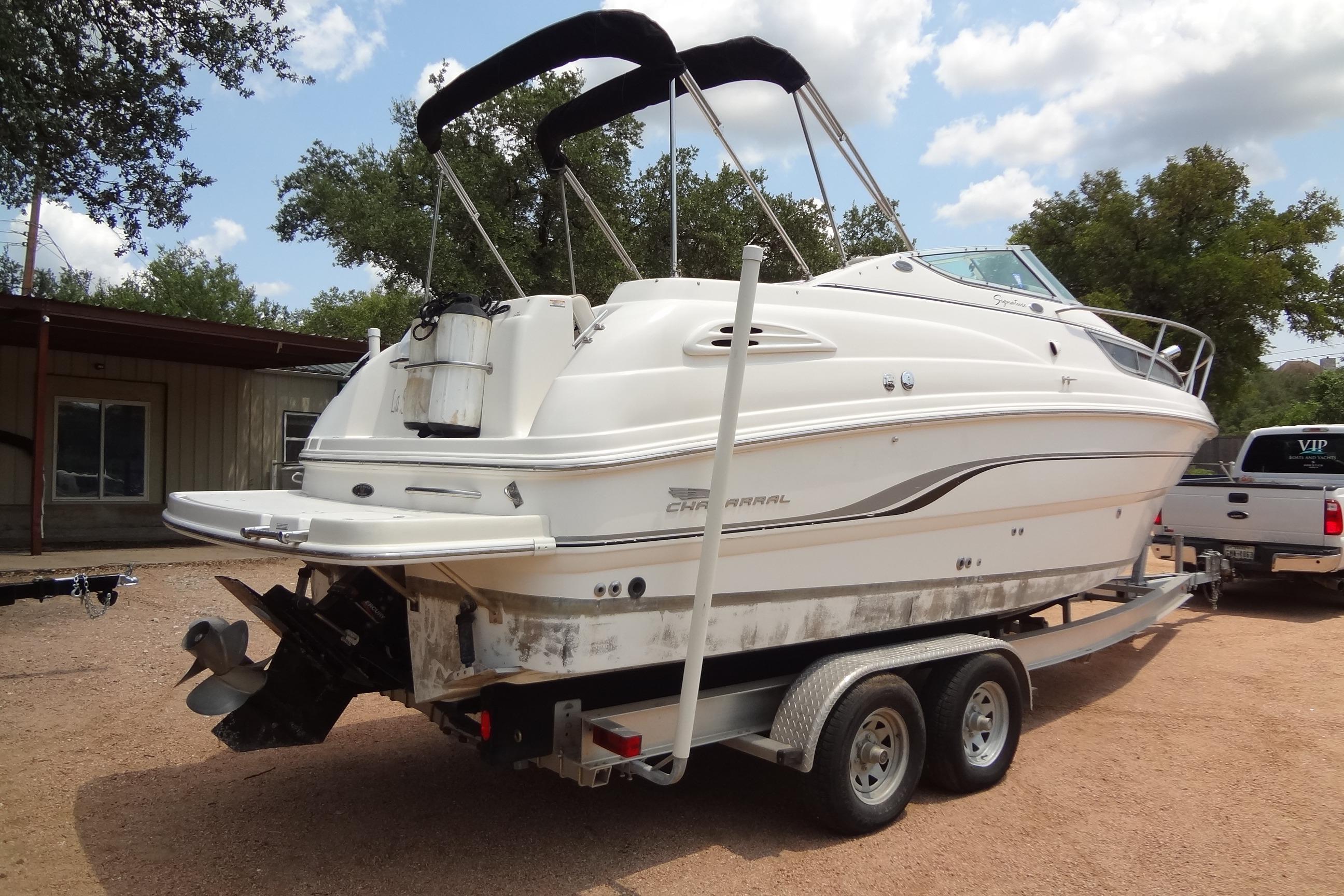 2000 Chaparral Signature 260 boat on trailer, parked outdoors under a partly cloudy sky.