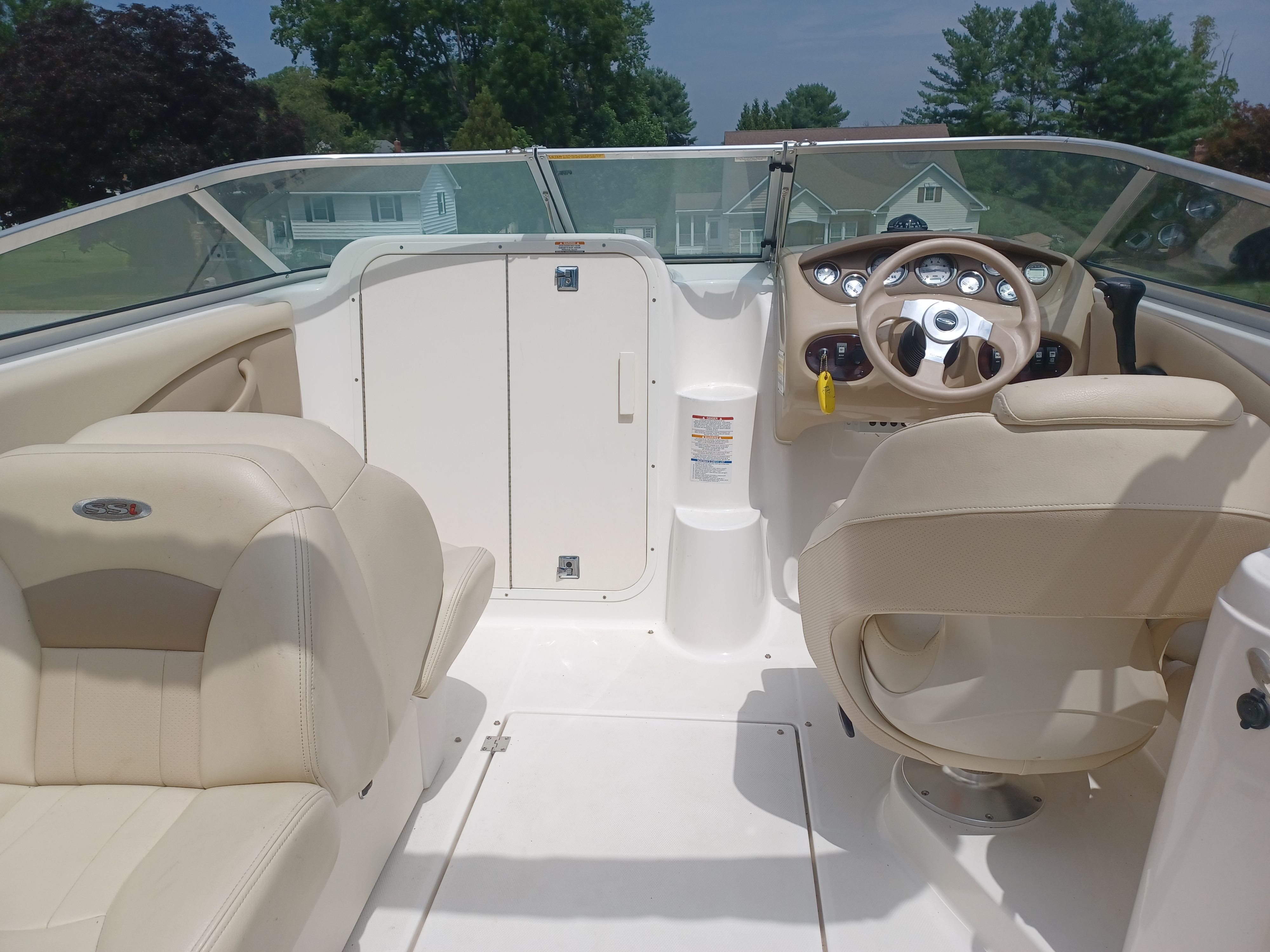 The image shows the cockpit of a 2004 Chaparral 215 SSi with beige leather seats.
