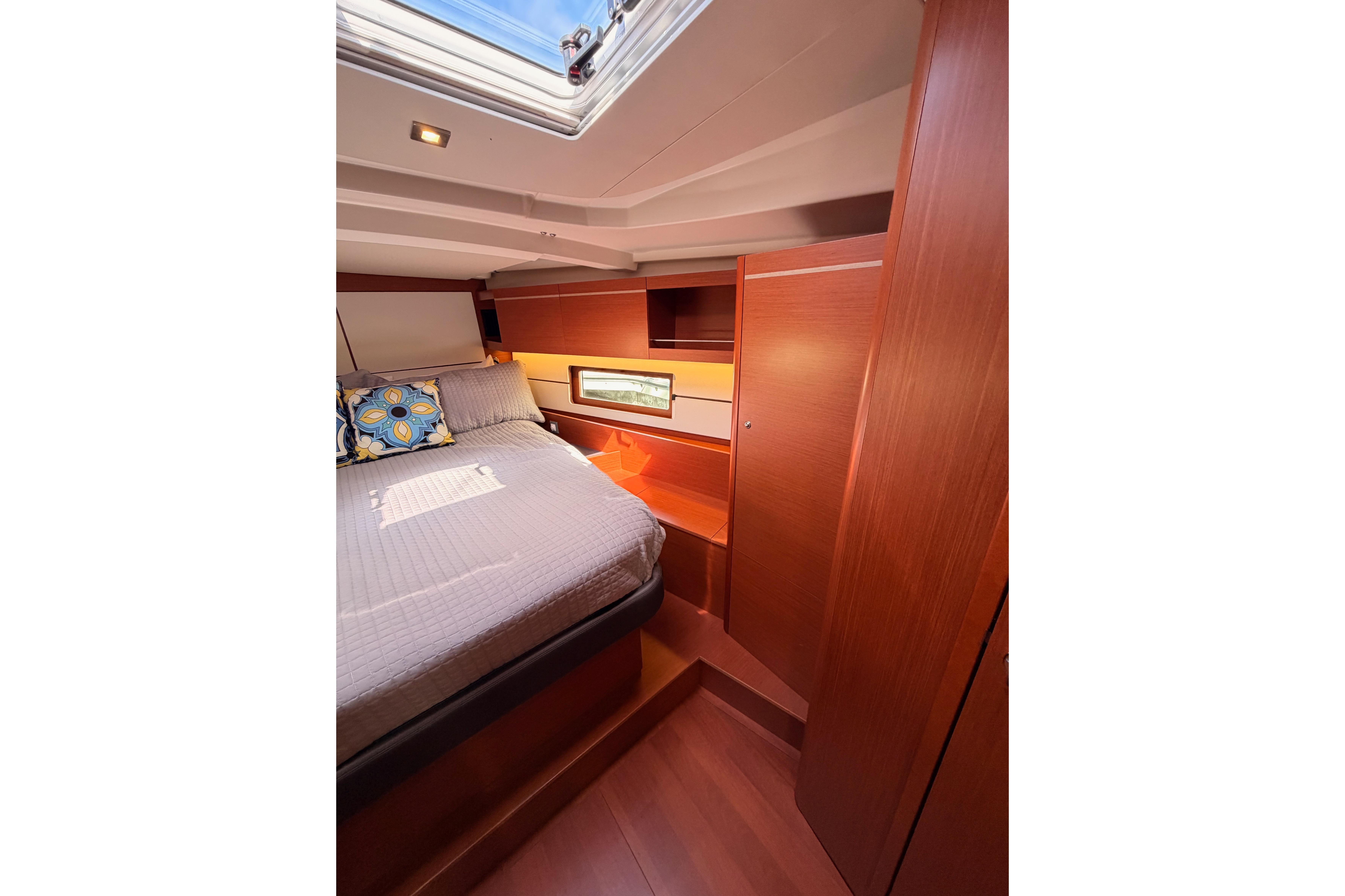 Luxurious cabin interior of 2020 Beneteau Oceanis 46.1 yacht with skylight and cozy bedding.