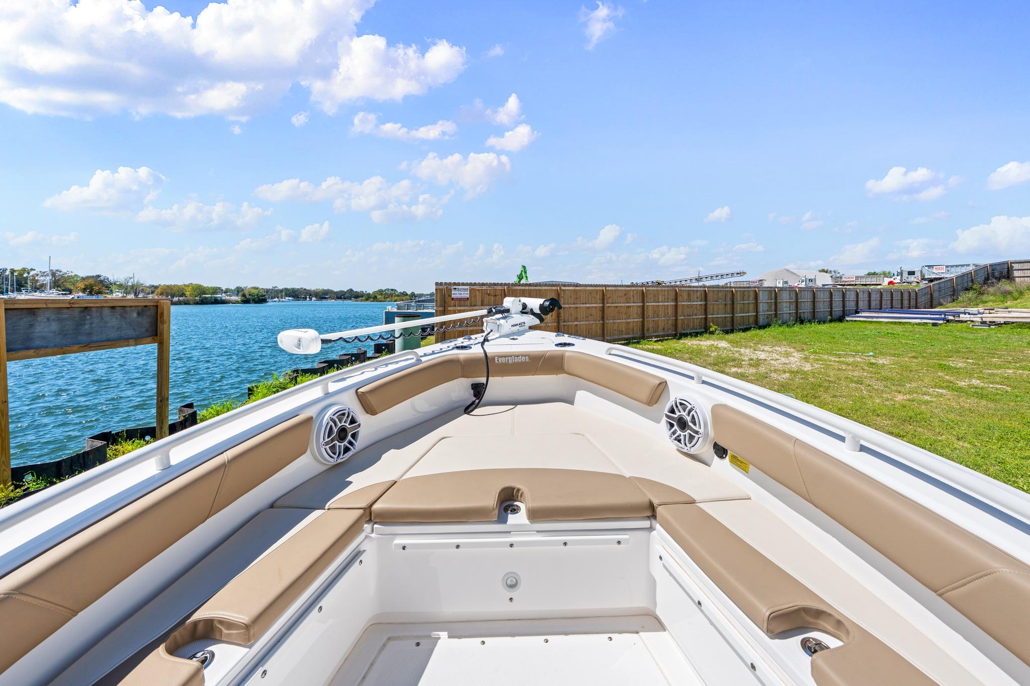 2023 Everglades 243 Center Console boat docked by a scenic waterfront.