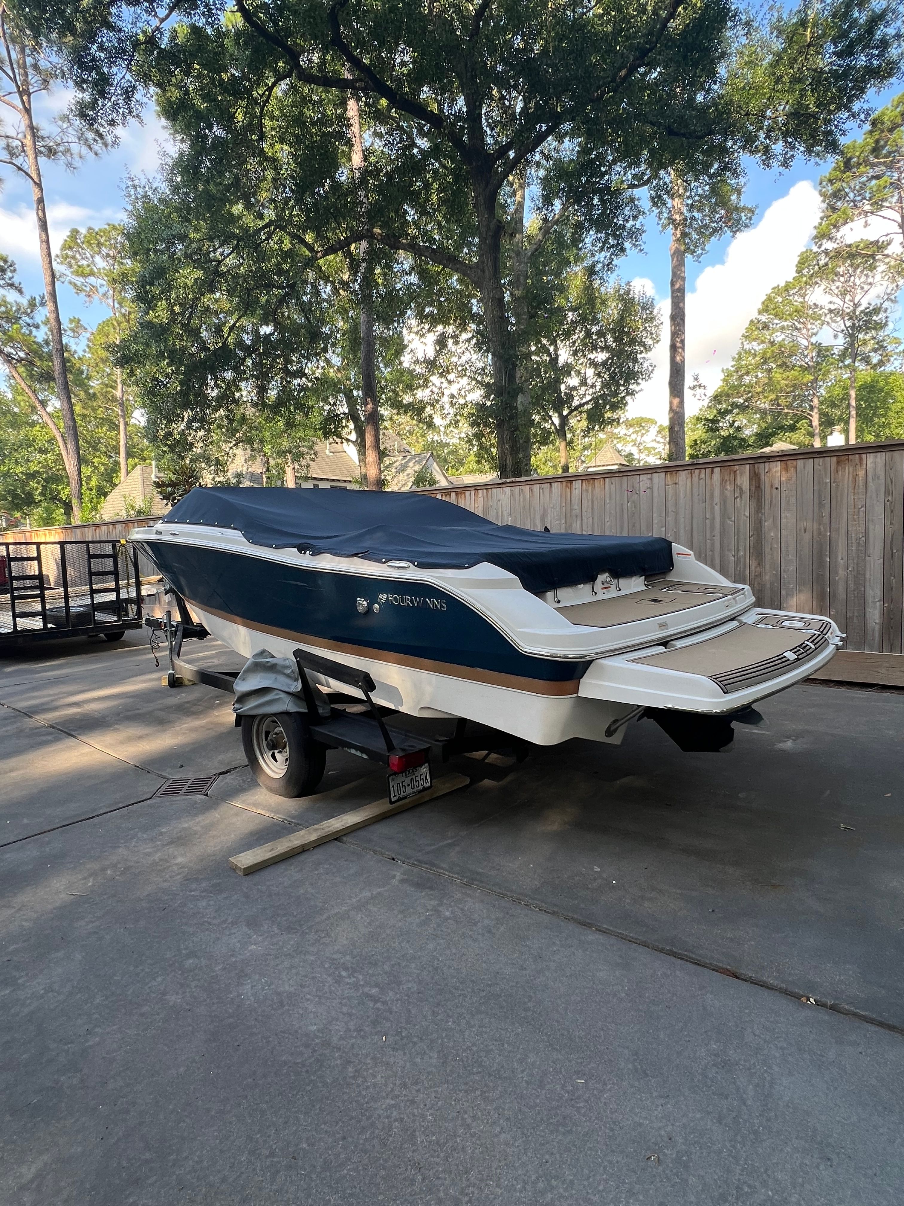 2017 Four Winns H230 boat parked on trailer outdoors.