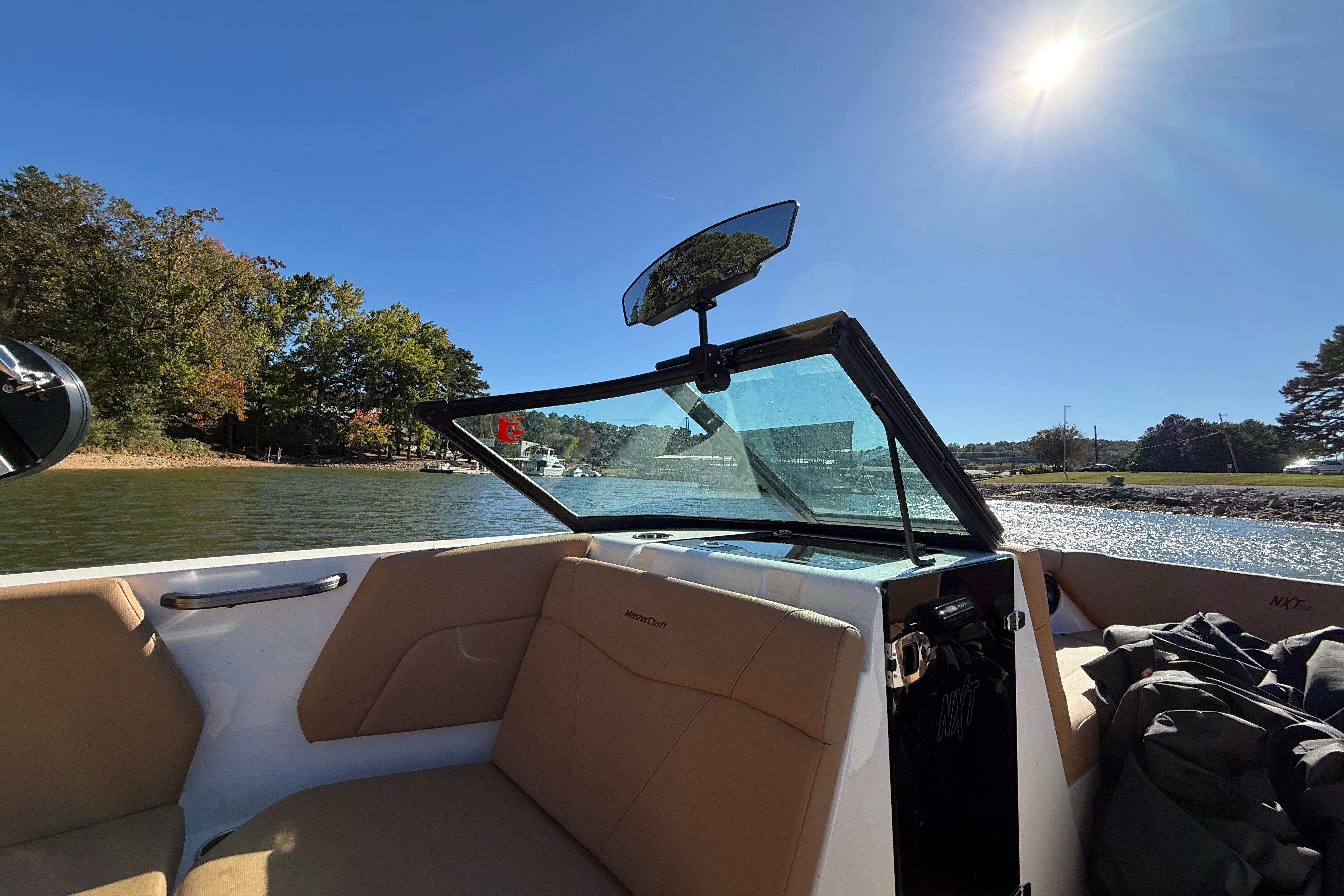 2022 MasterCraft NXT24 boat interior with tan seats, on a sunny day by the water.